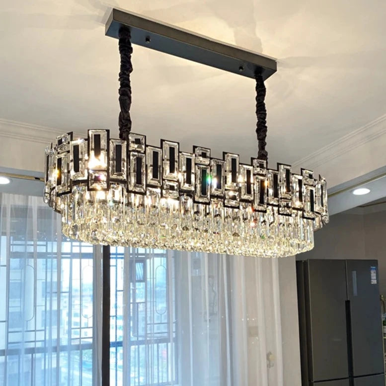 Rectangular crystal chandelier suspended above a modern dining setting.
