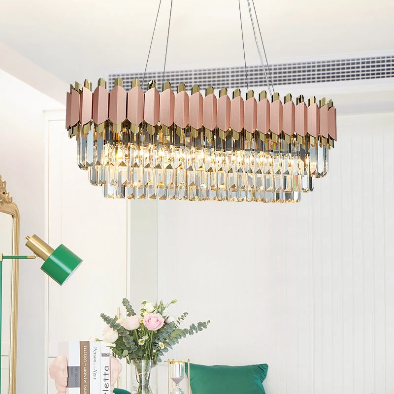 Rectangular chandelier with rose gold detailing and pink faceted crystals in a modern room.