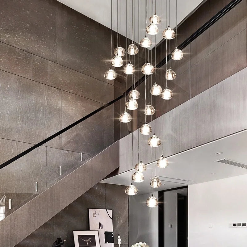 Biella pendant staircase chandelier with cascading glass drops illuminating a modern stairwell.