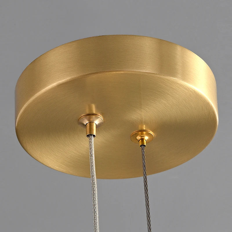 Gold ceiling canopy and suspension detailing of the Bocelli pendant light.