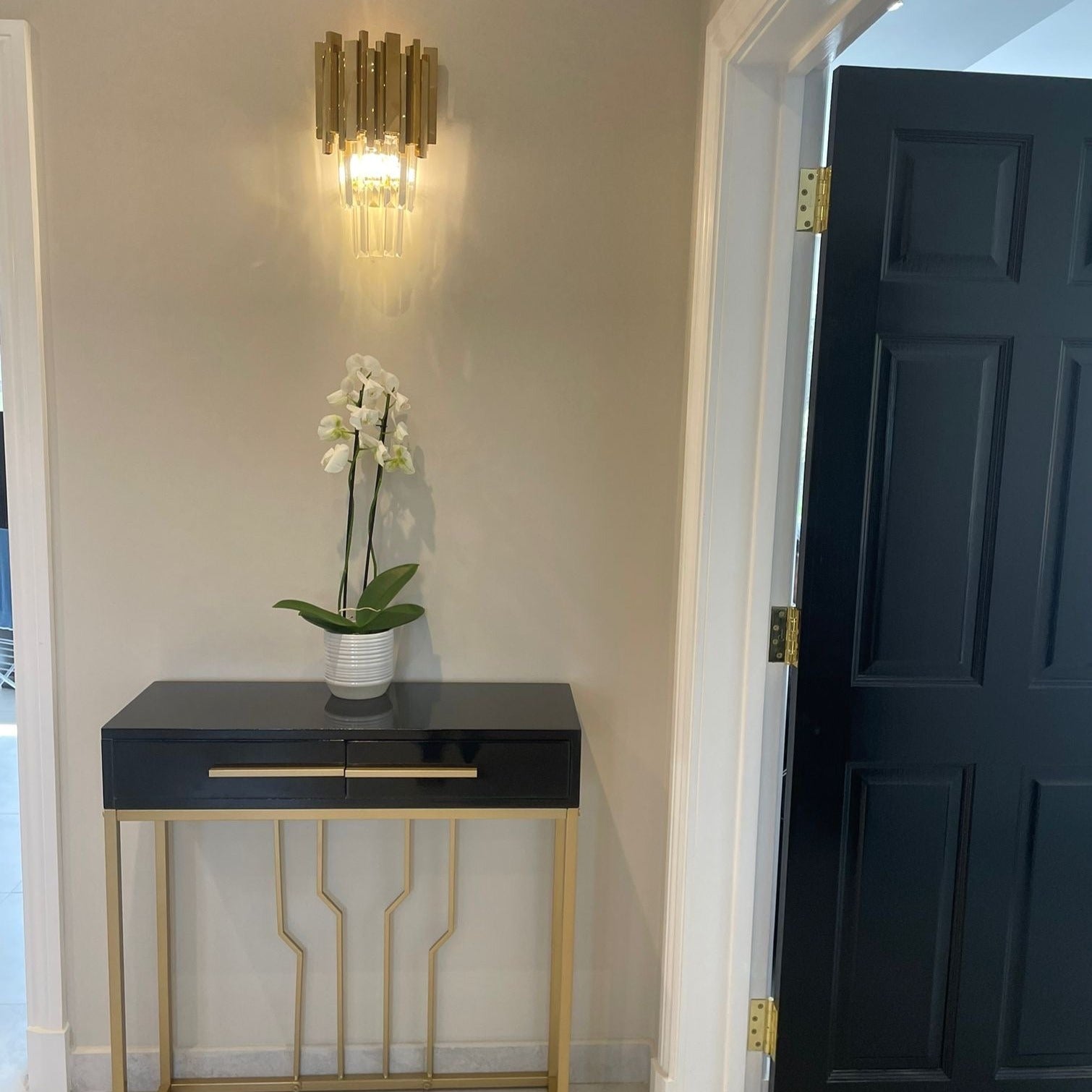 Boeotia Wall Light II installed in a hallway, showcasing its sleek modern form and refined crystal detailing.