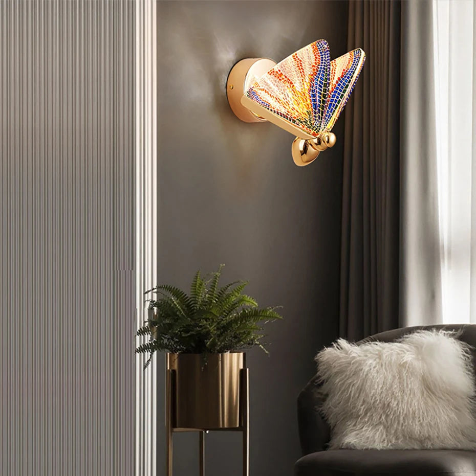 Butterfly Wall Light featuring sculpted iridescent glass wings mounted on a gold base, creating a soft, magical glow in a modern interior.
