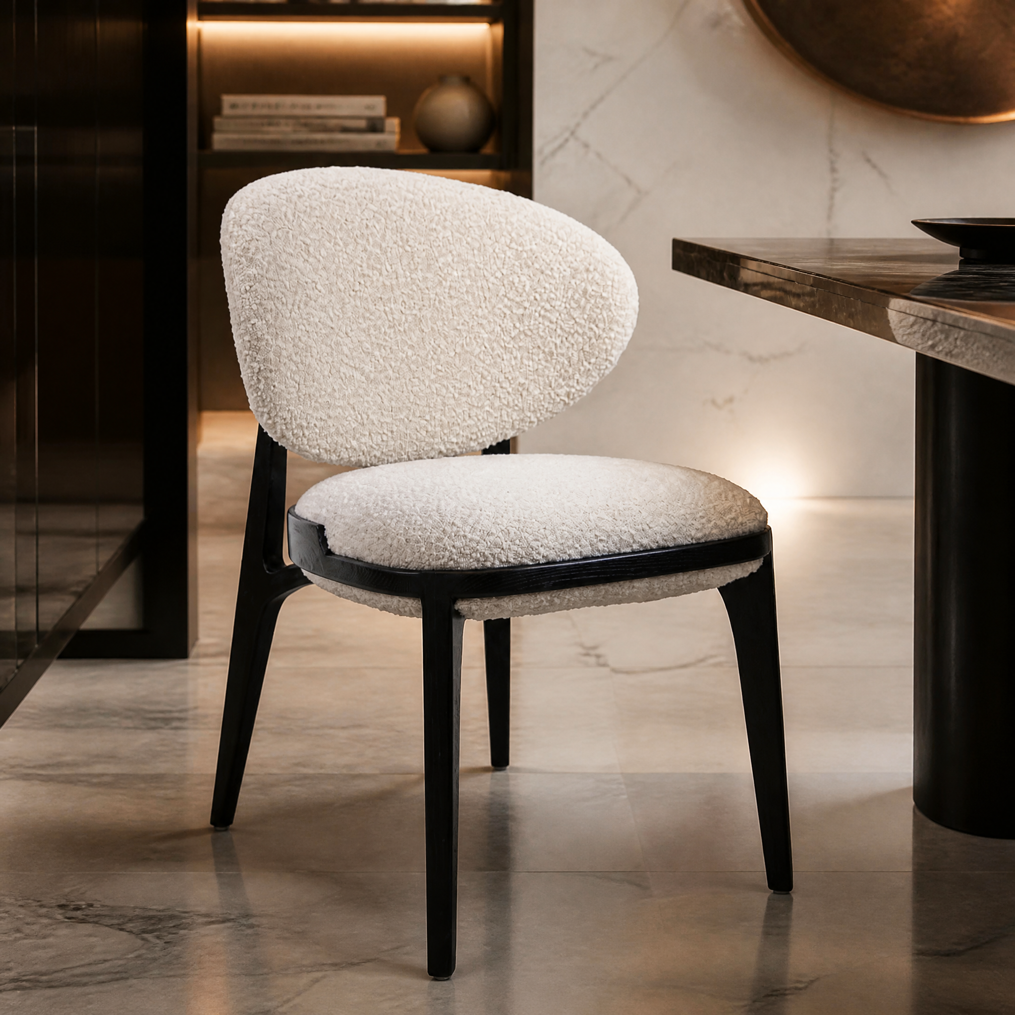 Close-up detail of the premium natural boucle upholstery and sleek black frame of the Cahrevo dining chair, highlighting texture and craft.