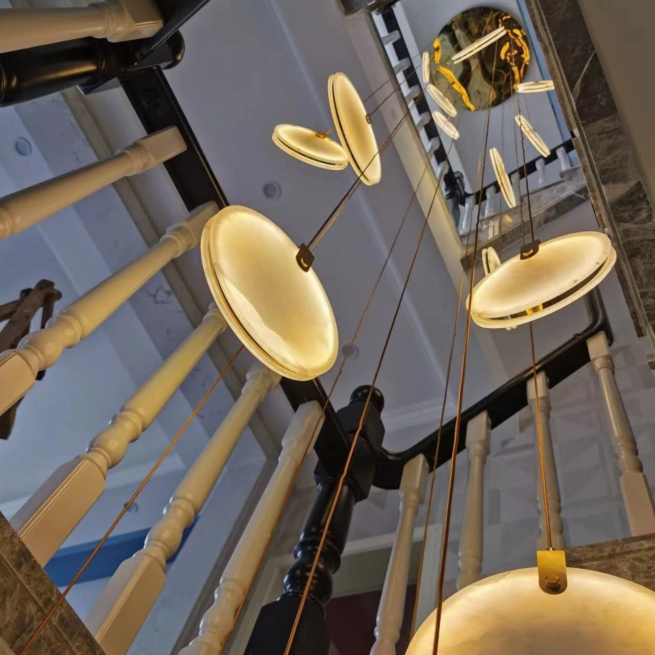 Close-up of the Calacatta Marble Pendant Staircase Chandelier illuminating a contemporary stairwell.