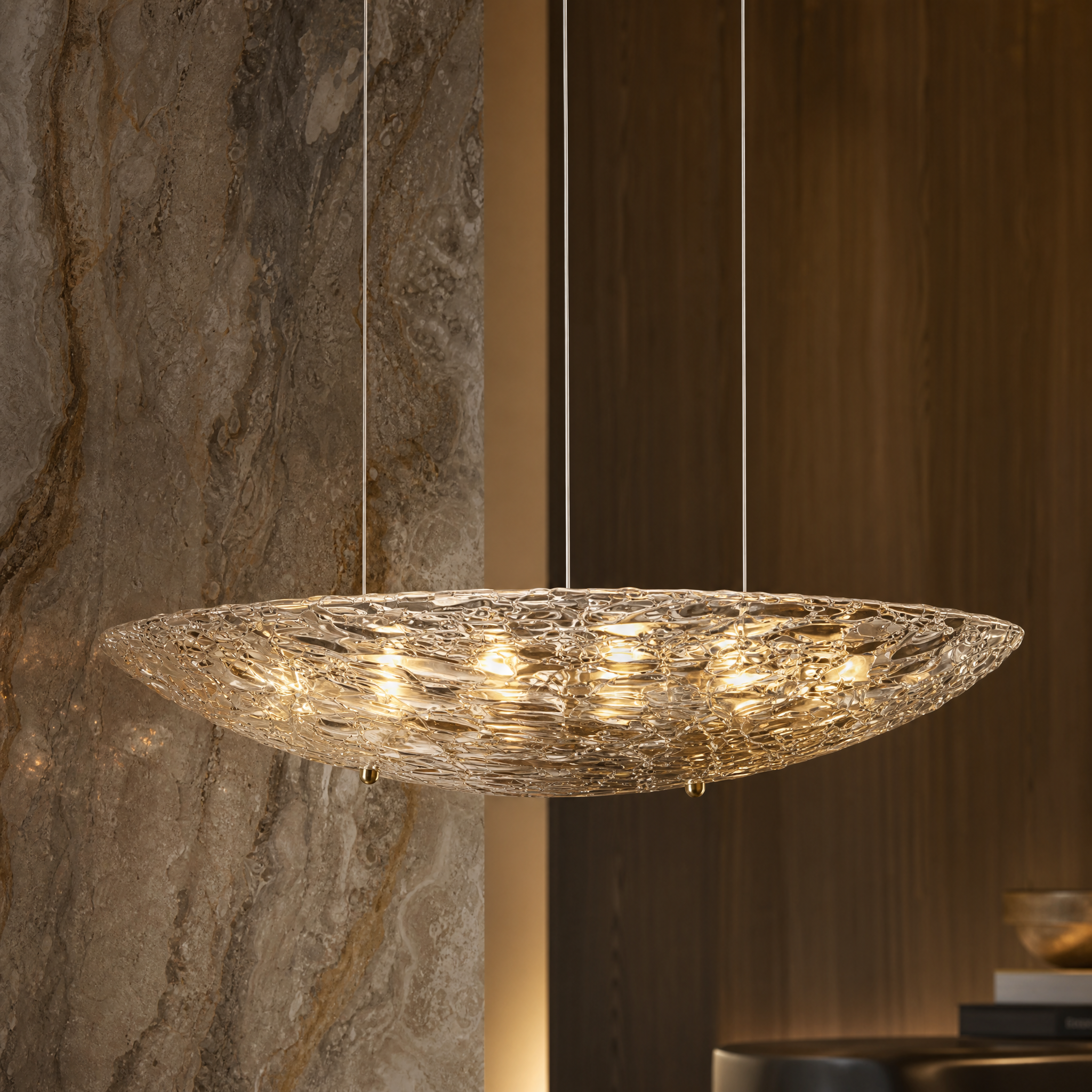 A detailed close-up shot of the VORELLI Cascata pendant light, showcasing the intricate texture and fluid craftsmanship of the sculpted glass shade.