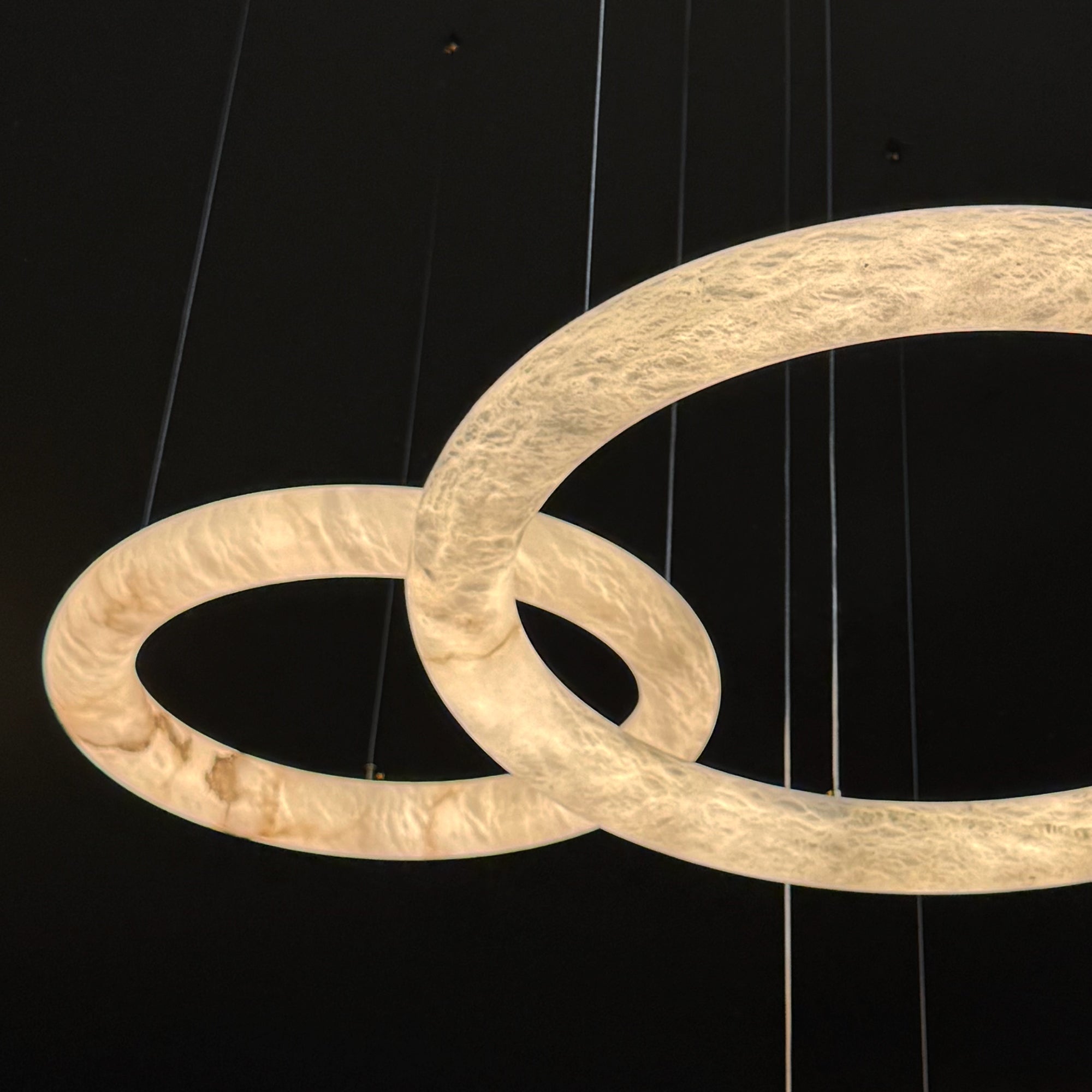 Angled view of the Cavani Marble Double Ring Chandelier showcasing its sculptural marble rings and refined illumination