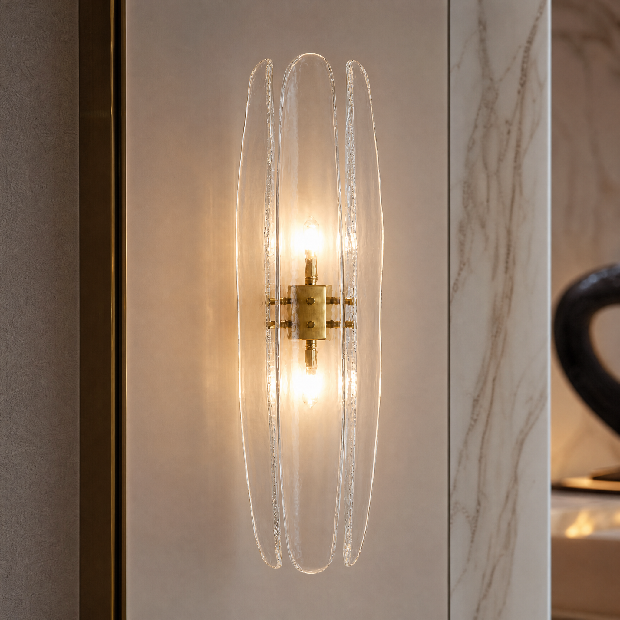 Detailed closeup of the VORELLI Dalia wall light showcasing three clear curved petal-shaped glass shades and minimal brass fixtures.
