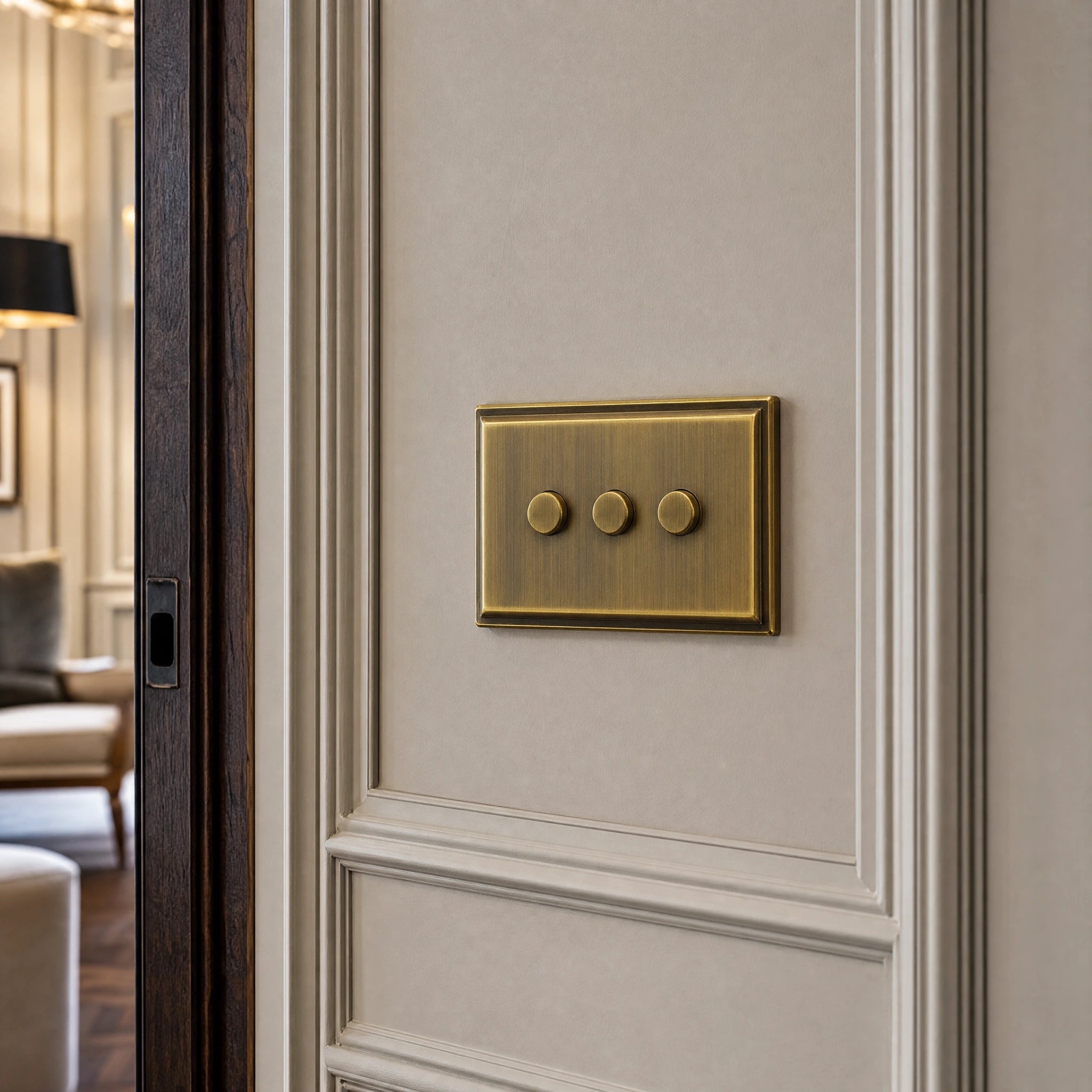 Close-up of a luxury antique brass dimmer switch installed within feature wall beside an elegant doorway in a Belgravia-style residence by VORELLI®.