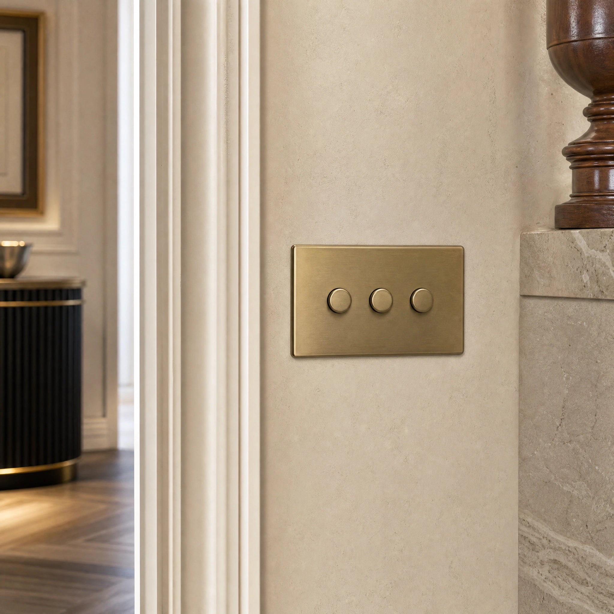 Close-up of a luxury antique brass dimmer switch installed within feature wall beside an elegant doorway in a Belgravia-style residence by VORELLI®.