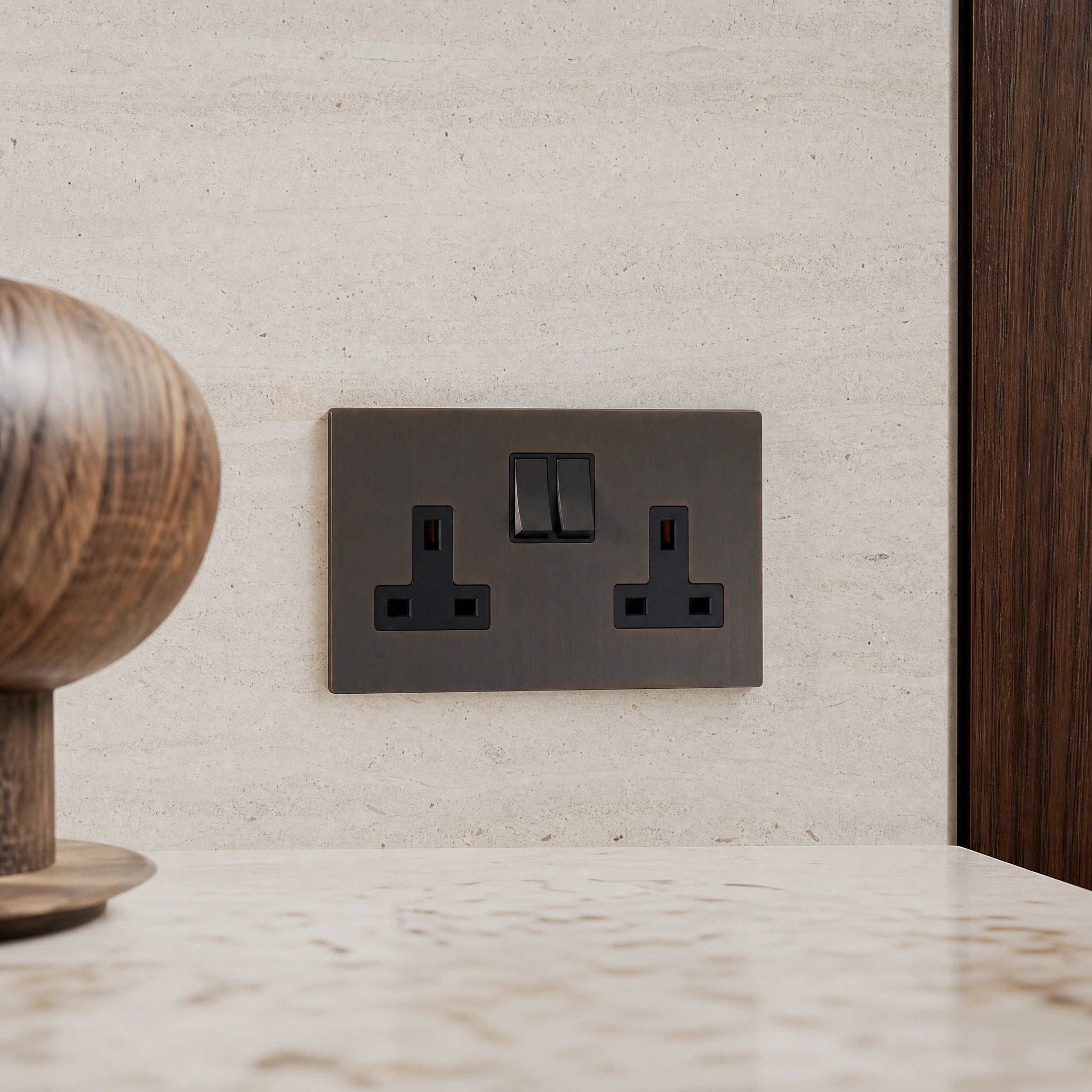 Close-up of a luxury sienna double socket installed within bespoke walnut cabinetry or stone worktop in a luxury residence by VORELLI®.