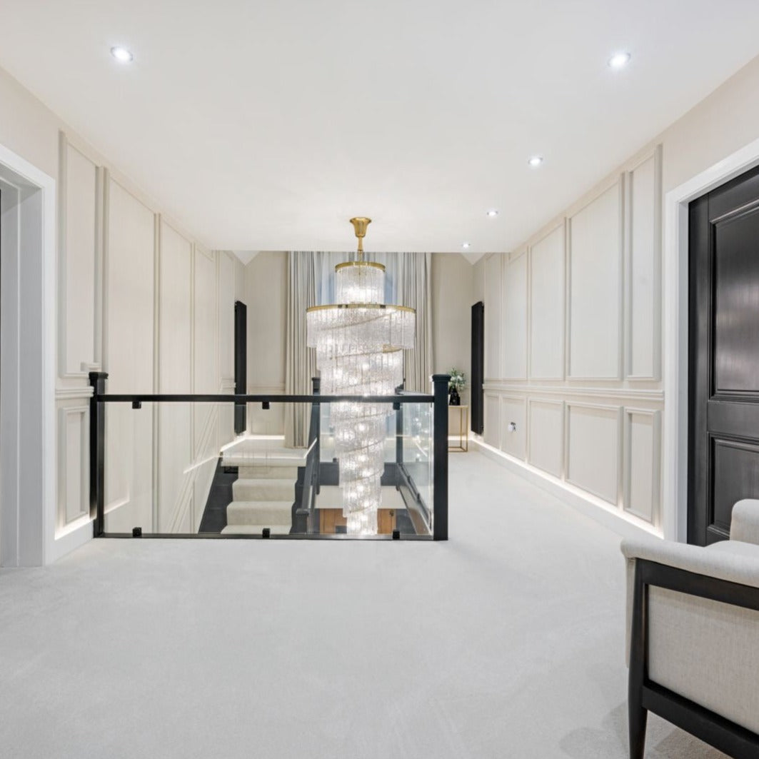 VORELLI Dunleavy spiral staircase chandelier in a luxury stairwell with cascading crystal tiers