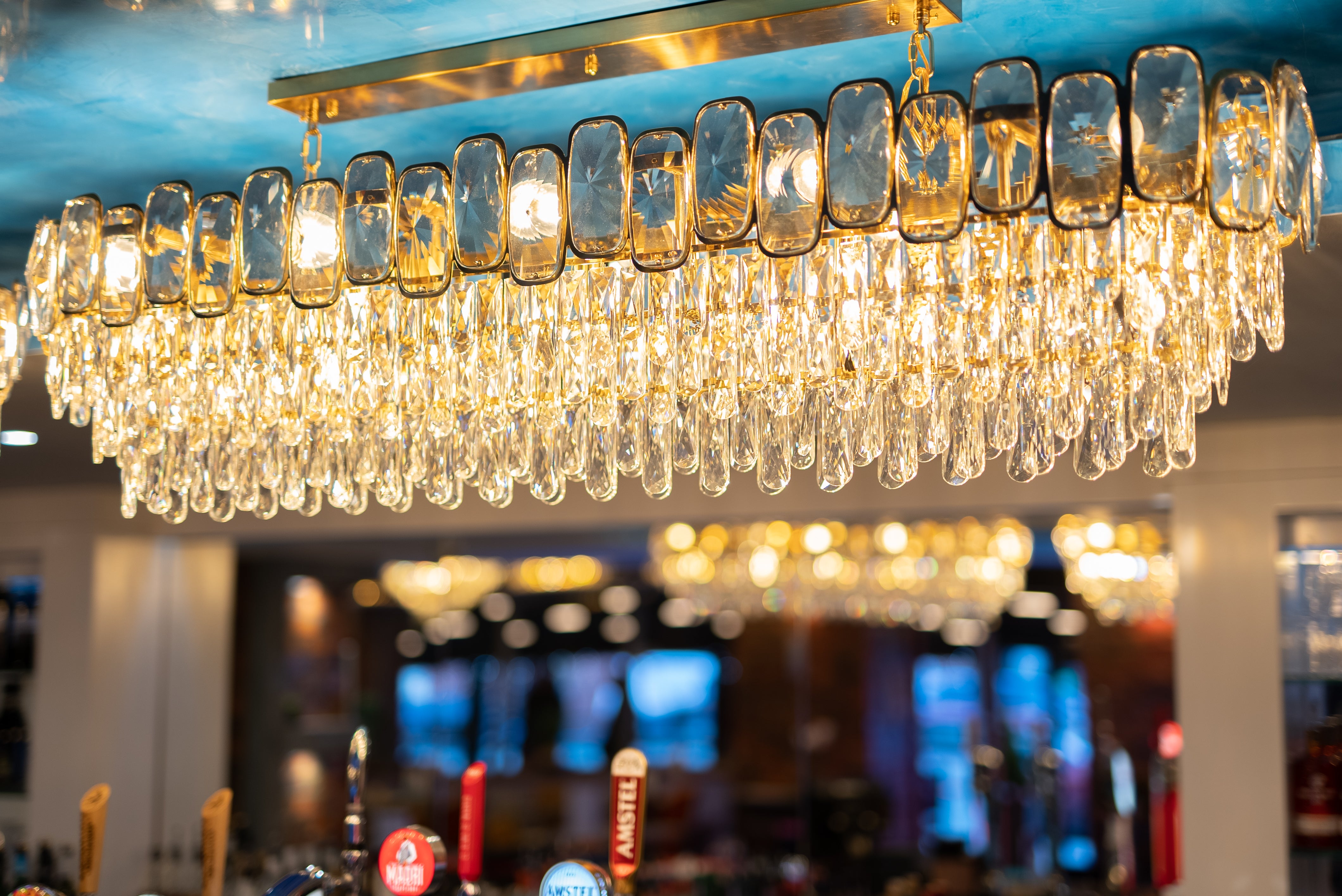 Edmond rectangular crystal chandelier above luxury bar counter