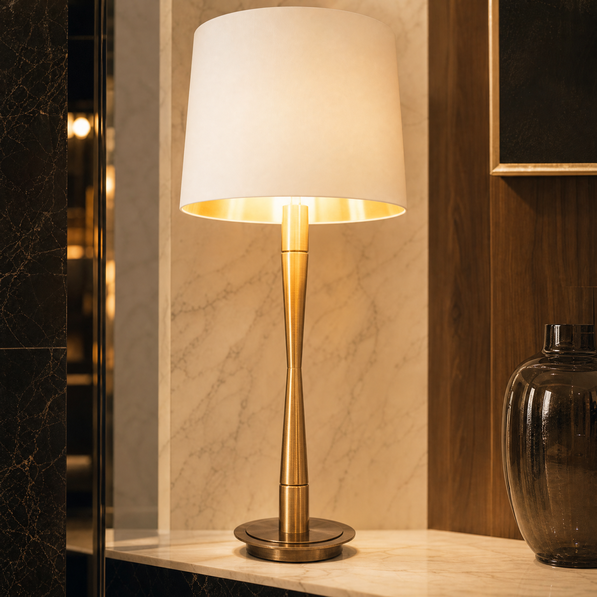 Detailed closeup of the VORELLI Elvaron table lamp highlighting the textured finish of its sculpted antique brass base and premium opal fabric shade.