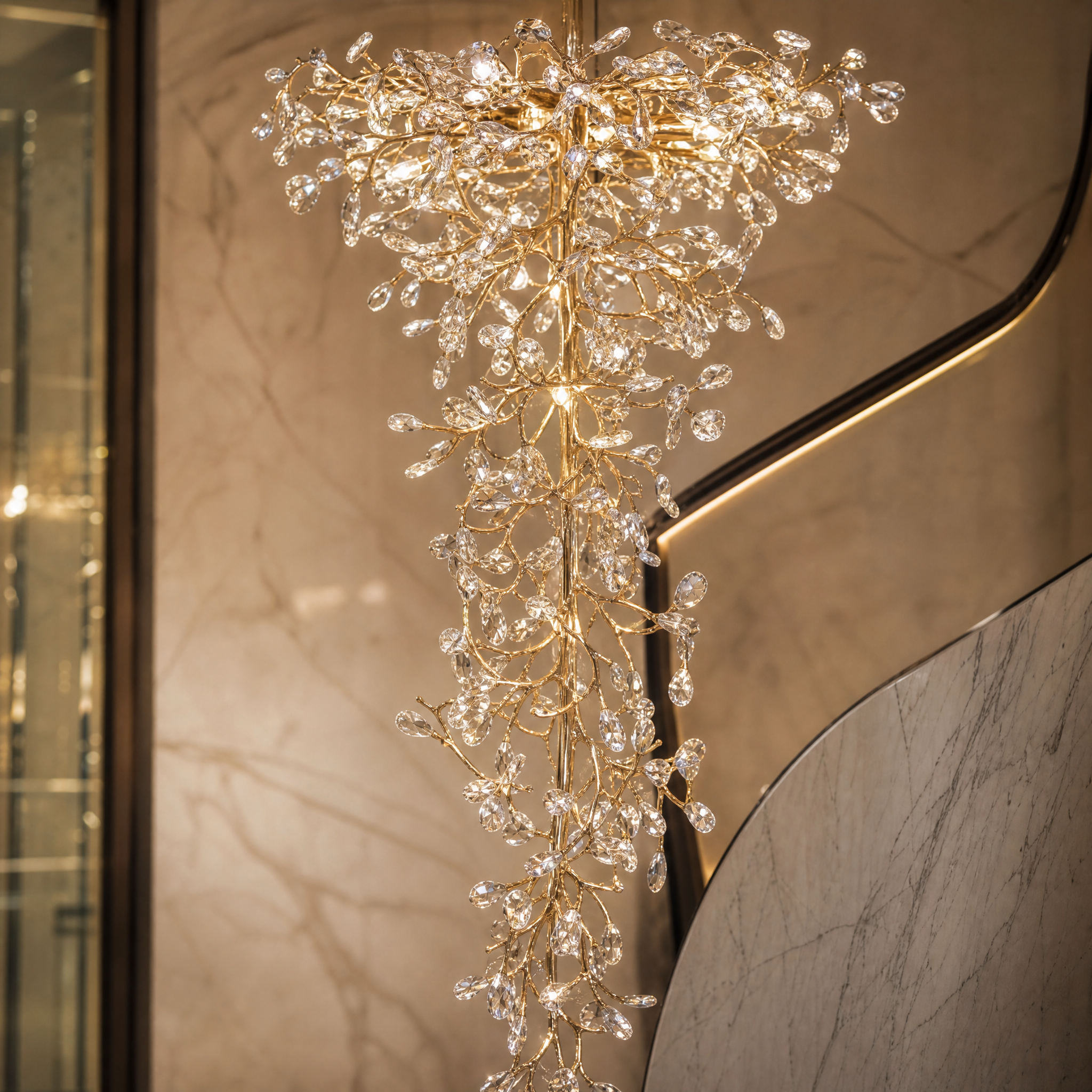 Macro closeup of the organic form and cascading crystal prisms of the VORELLI Entwine luxury chandelier.