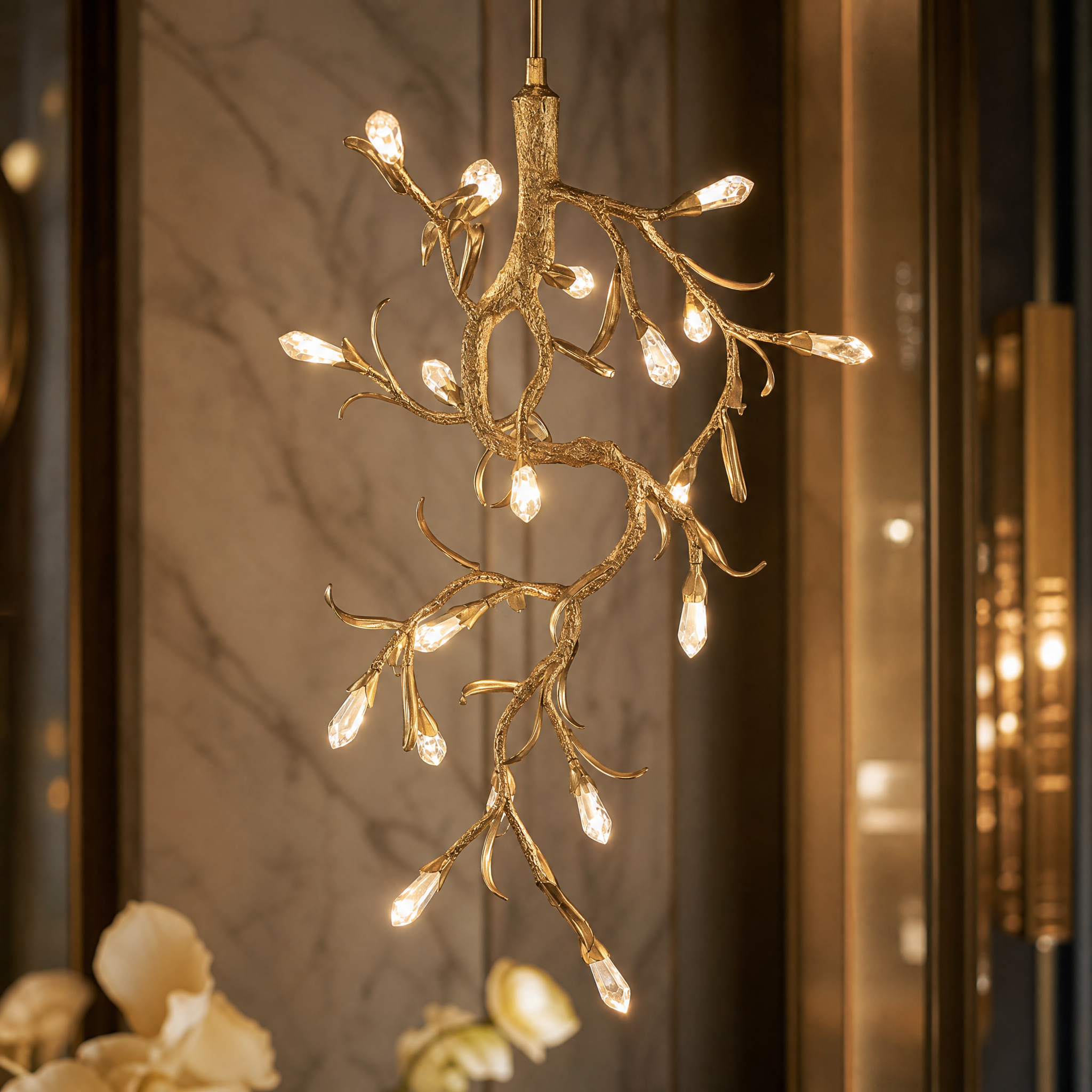 A detailed closeup of the VORELLI Entwine pendant light, showcasing the intricate diamond-cut crystal drops delicately adorned on flowing gold branches.