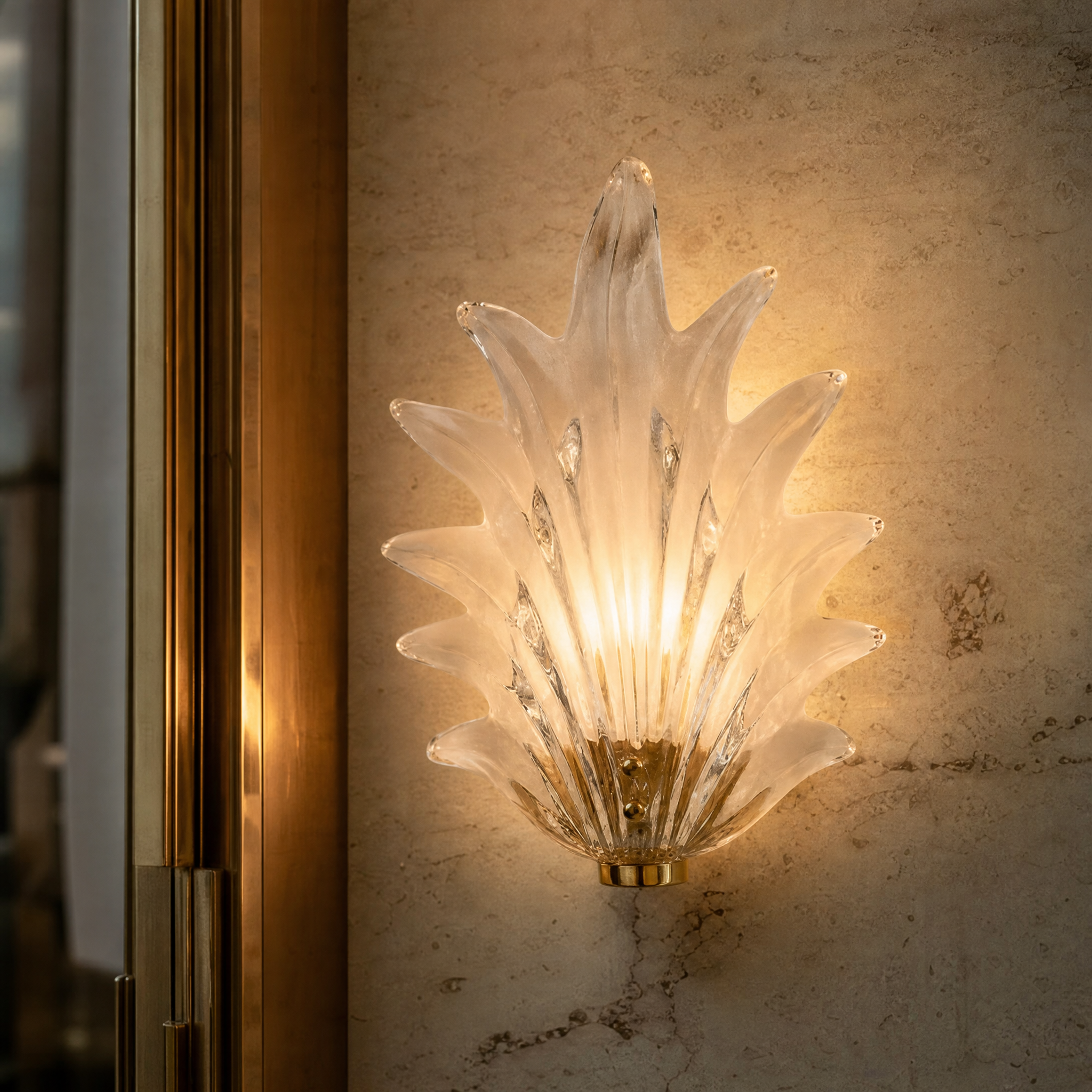 Detailed closeup of the VORELLI Fiorino wall light highlighting the delicate flower-shaped clear glass shade and minimal brass fittings.