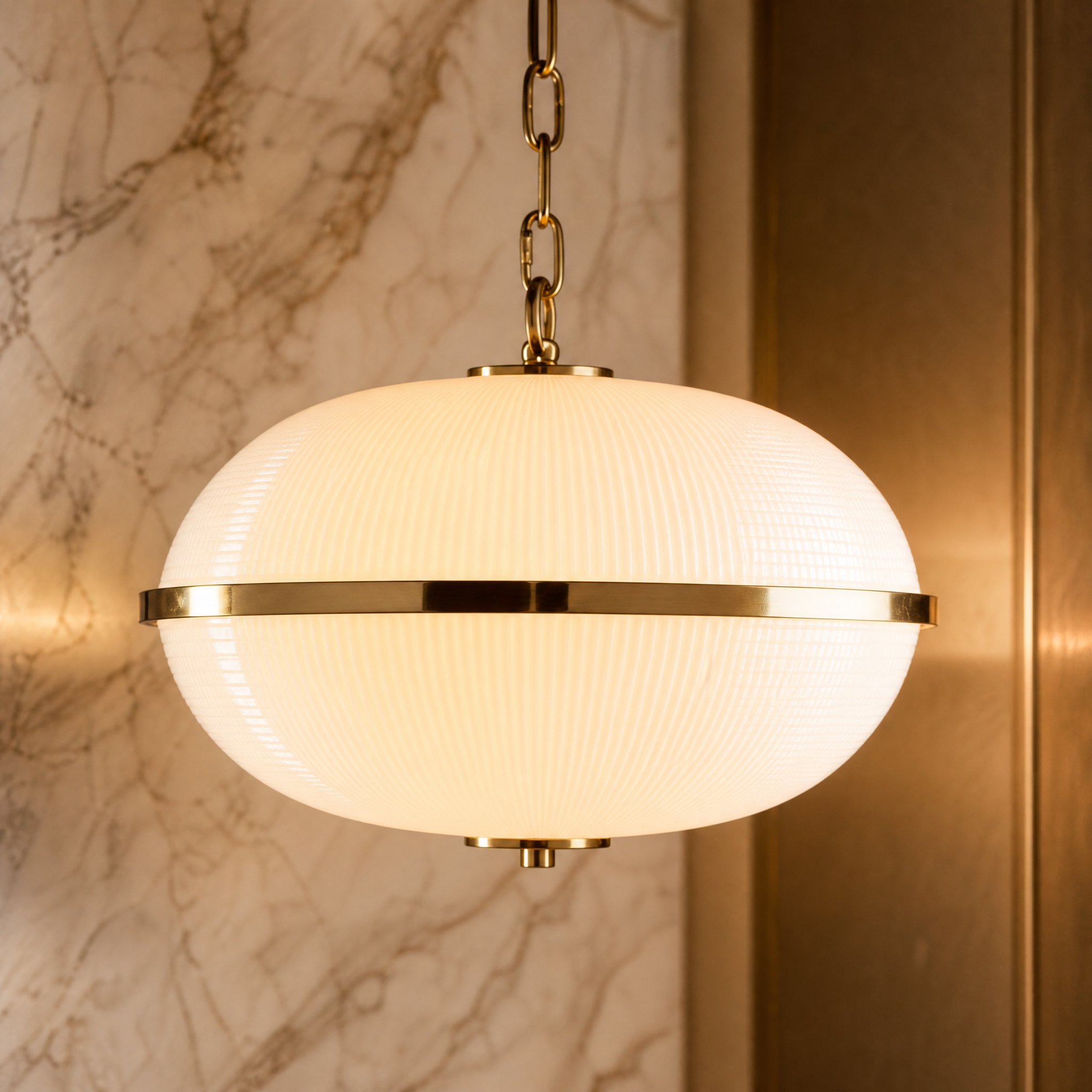 Macro closeup of the VORELLI Foscaro pendant light, showcasing the intricate texture of the opaline prismatic moulded glass and premium brass hardware.