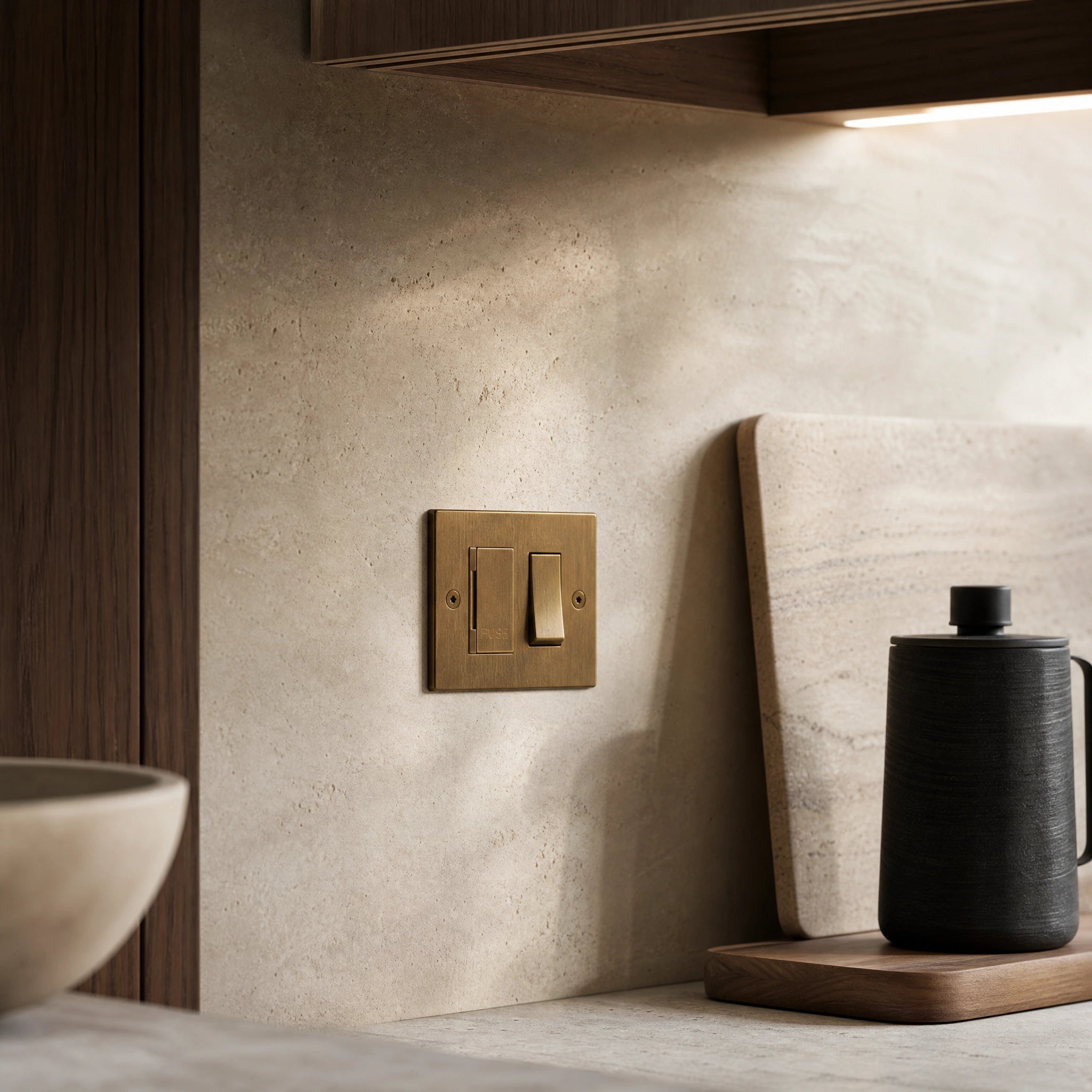 Luxury antique brass fused spur installed within discreet below-cabinet utility or kitchen appliance zone in a high-end residence in a UHNW interior by VORELLI®.