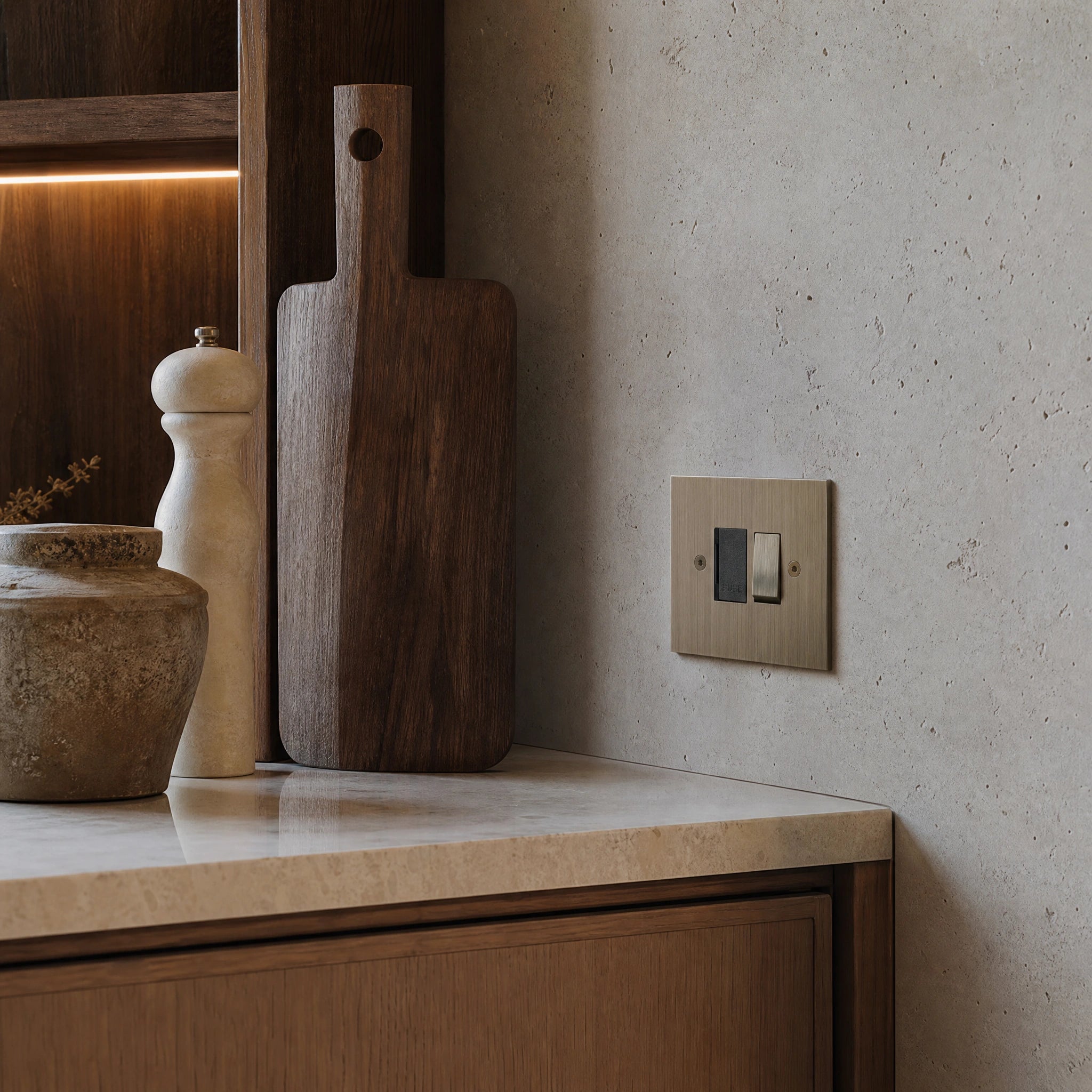 Luxury antique brass fused spur installed within discreet below-cabinet utility or kitchen appliance zone in a high-end residence in a UHNW interior by VORELLI®.