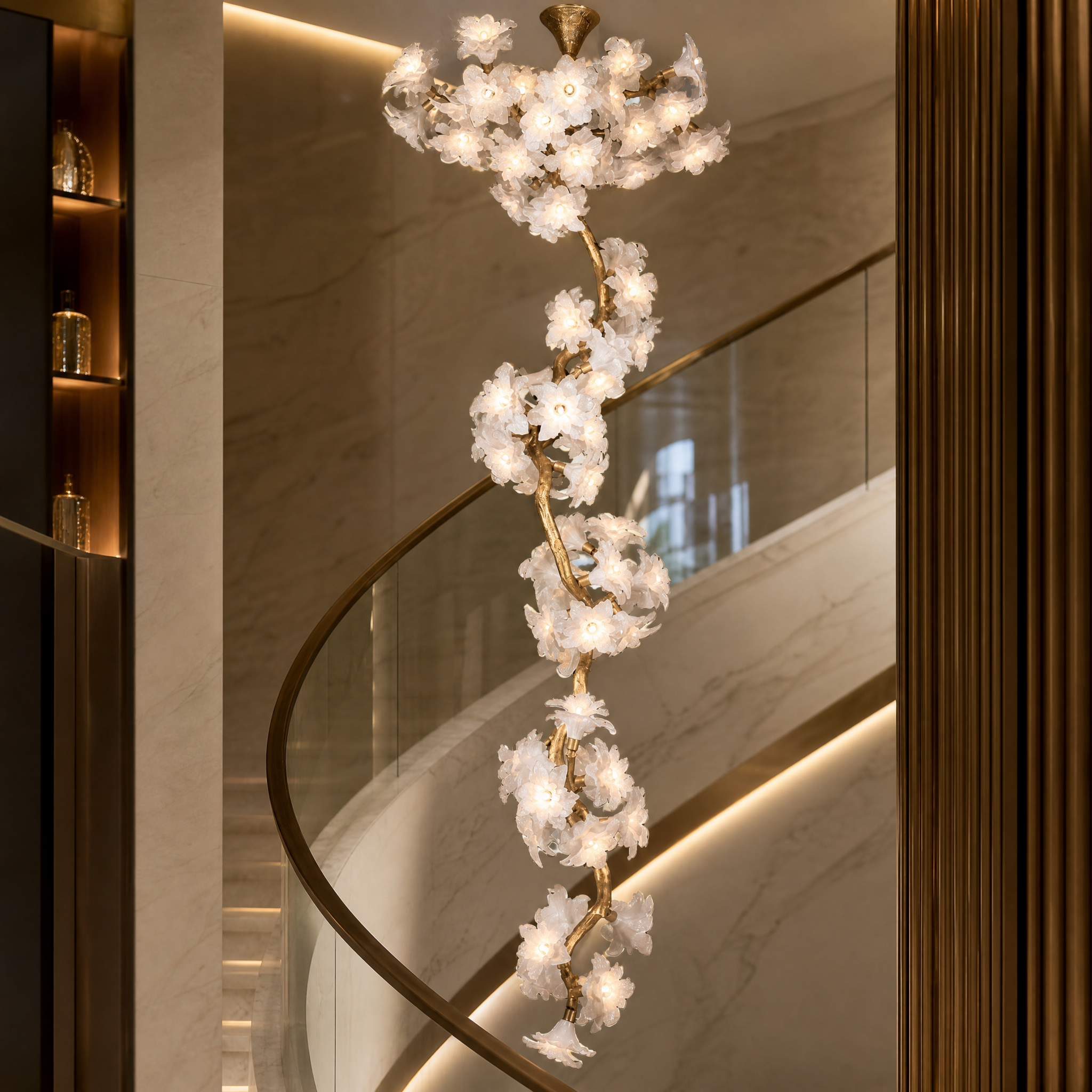 Close-up detail of the VORELLI Gardenia chandelier, showcasing the intricate illuminated floral glass blooms and sculptural branch form.