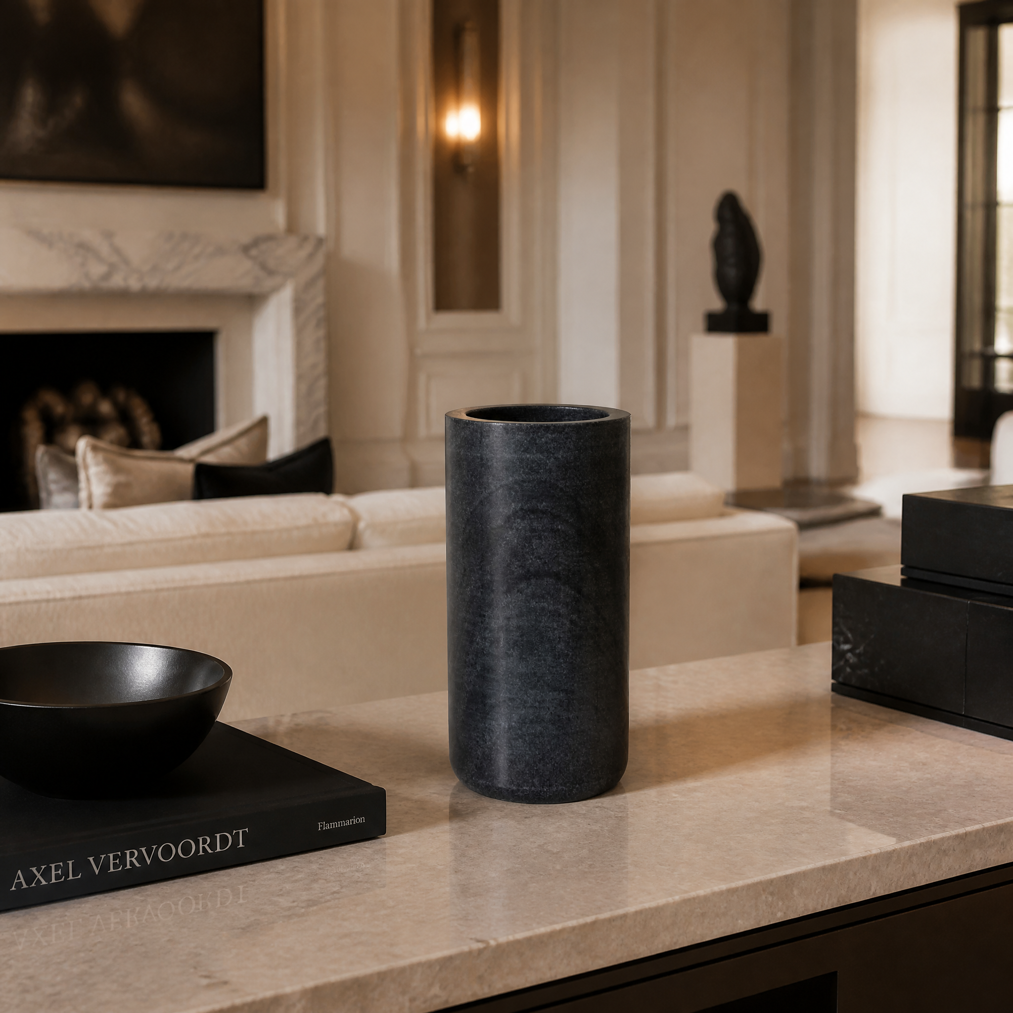 VORELLI Lunetta polished black marble vase styled on a modern residential living room console table with a single floral stem.