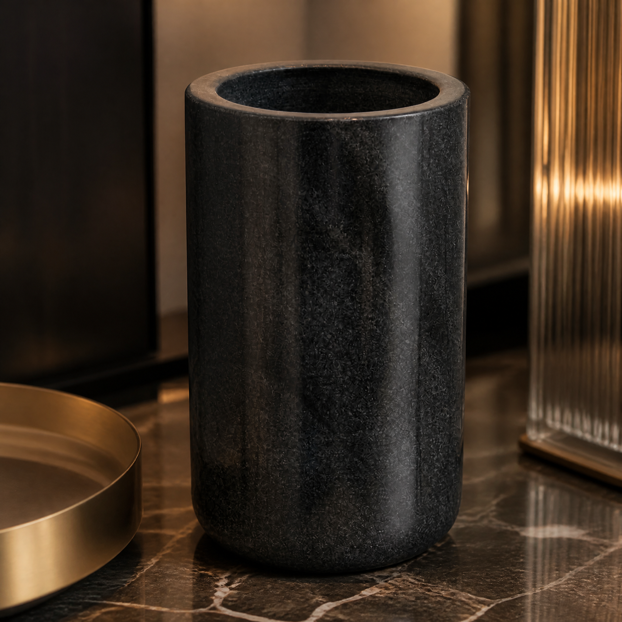 A detailed closeup capturing the smooth, clean-lined texture and natural veining of the VORELLI Lunetta black marble decorative vase.