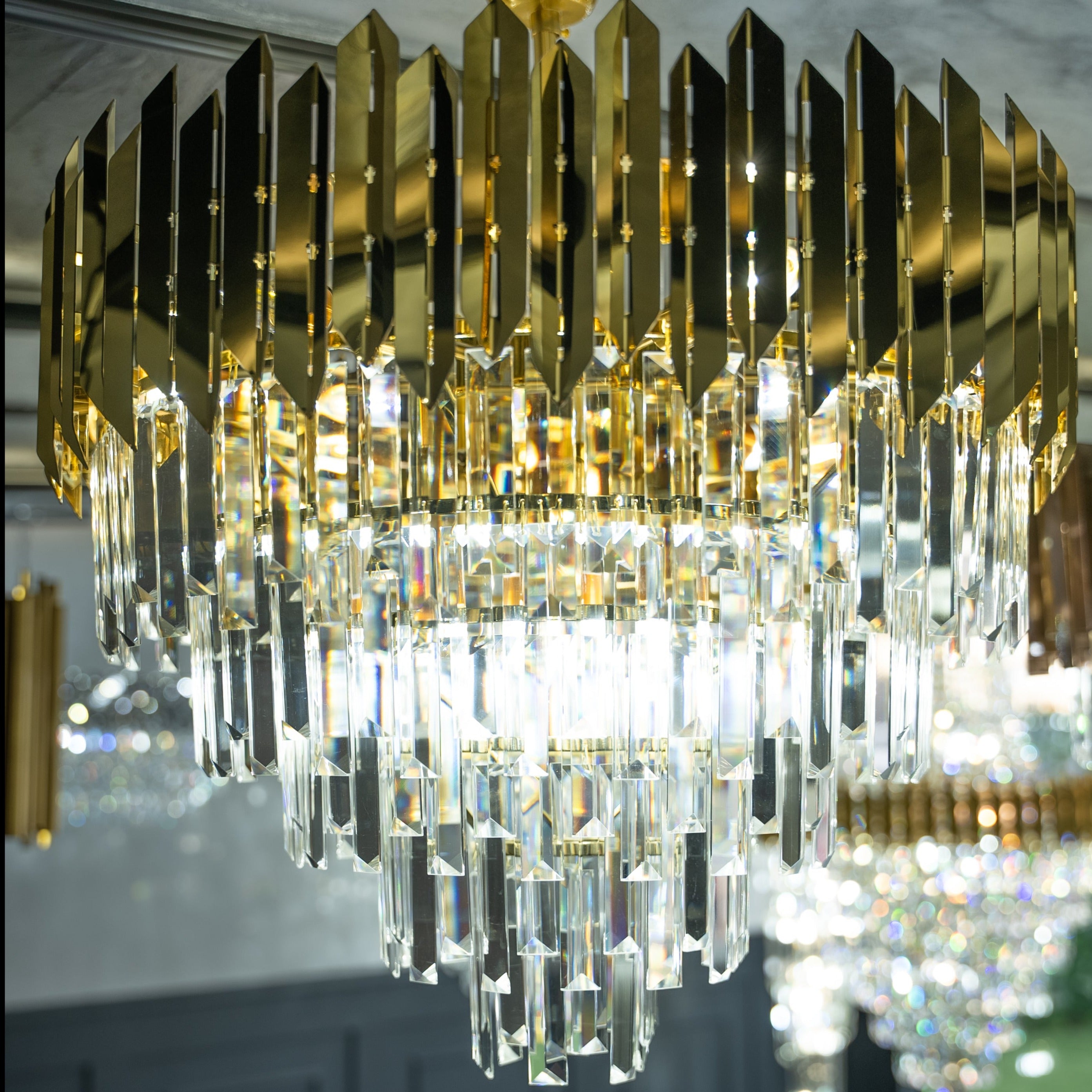 Close view of VORELLI Manhattan Circular Chandelier II showing layered crystal bars and glowing central formation