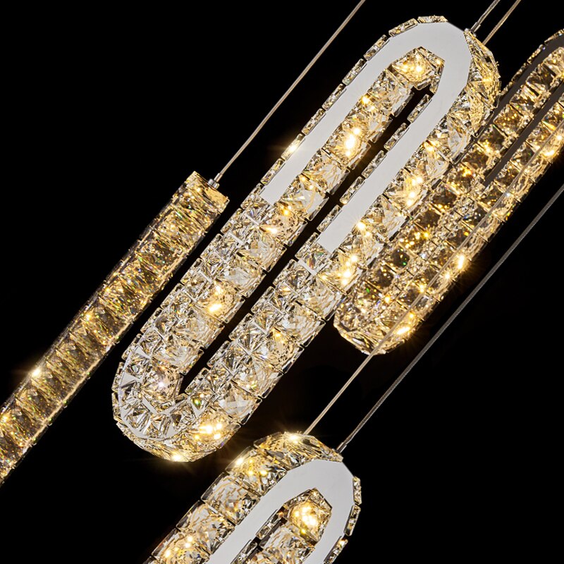 Illuminated crystal structure of the VORELLI Manzoni LED pendant staircase chandelier in a luxury interior