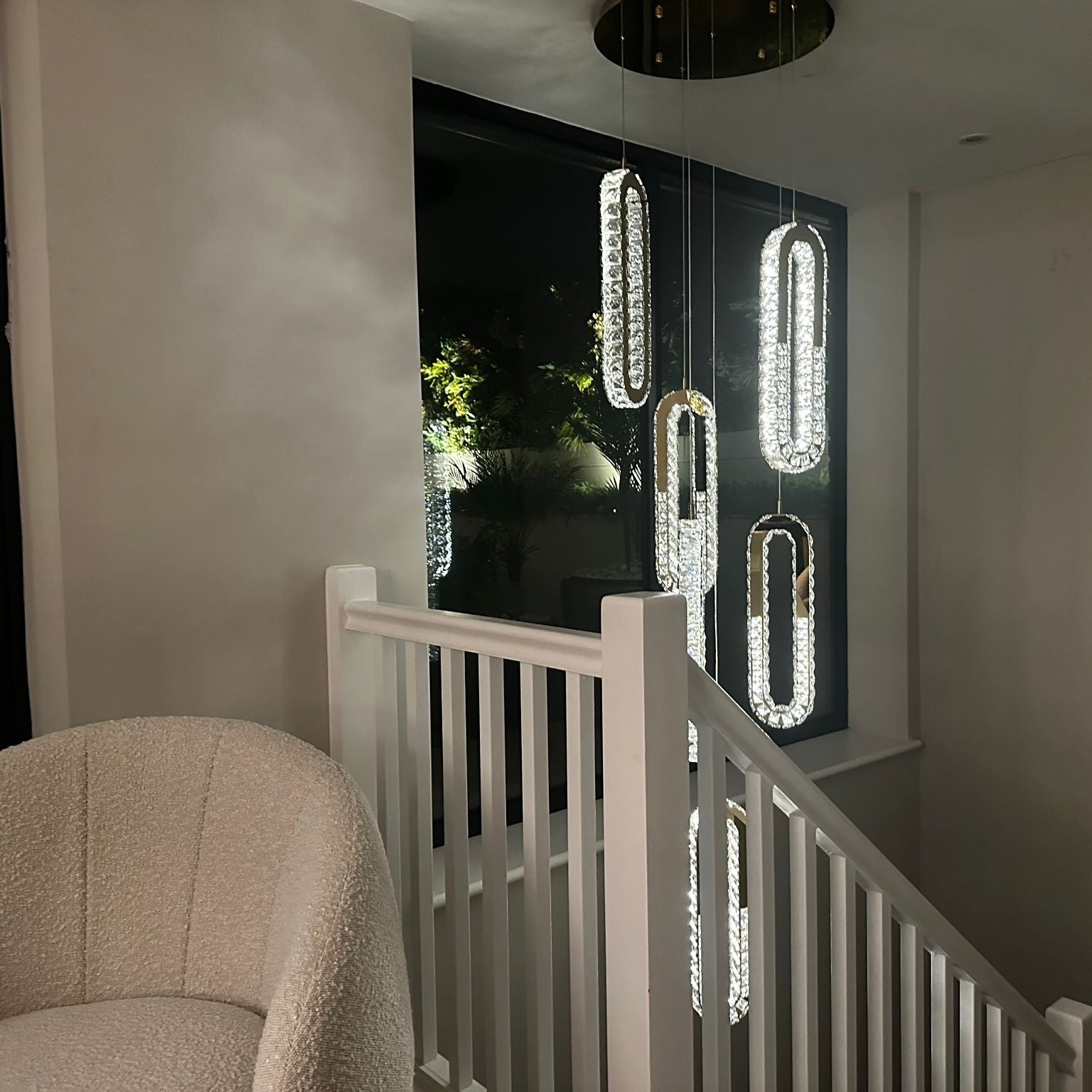 VORELLI Manzoni pendant staircase chandelier with modern crystal forms illuminating a luxury stairwell interior