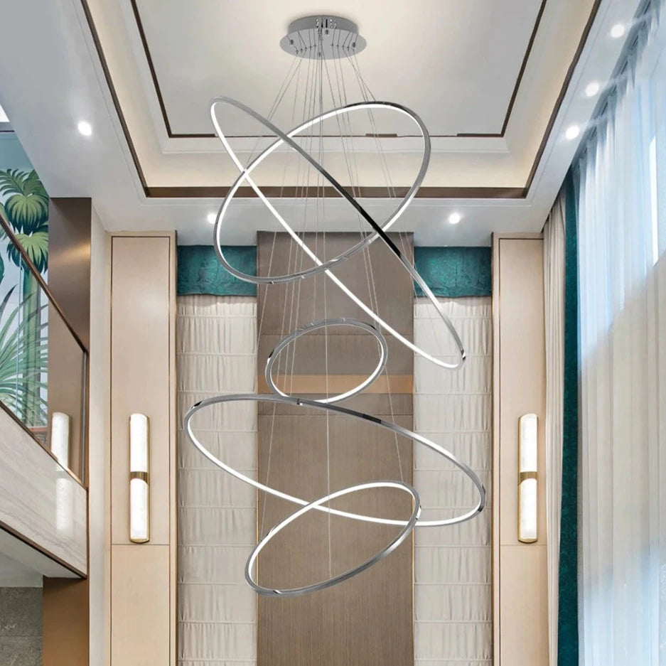 Floating LED ring chandelier by VORELLI suspended in a contemporary stairwell creating elegant ambient lighting