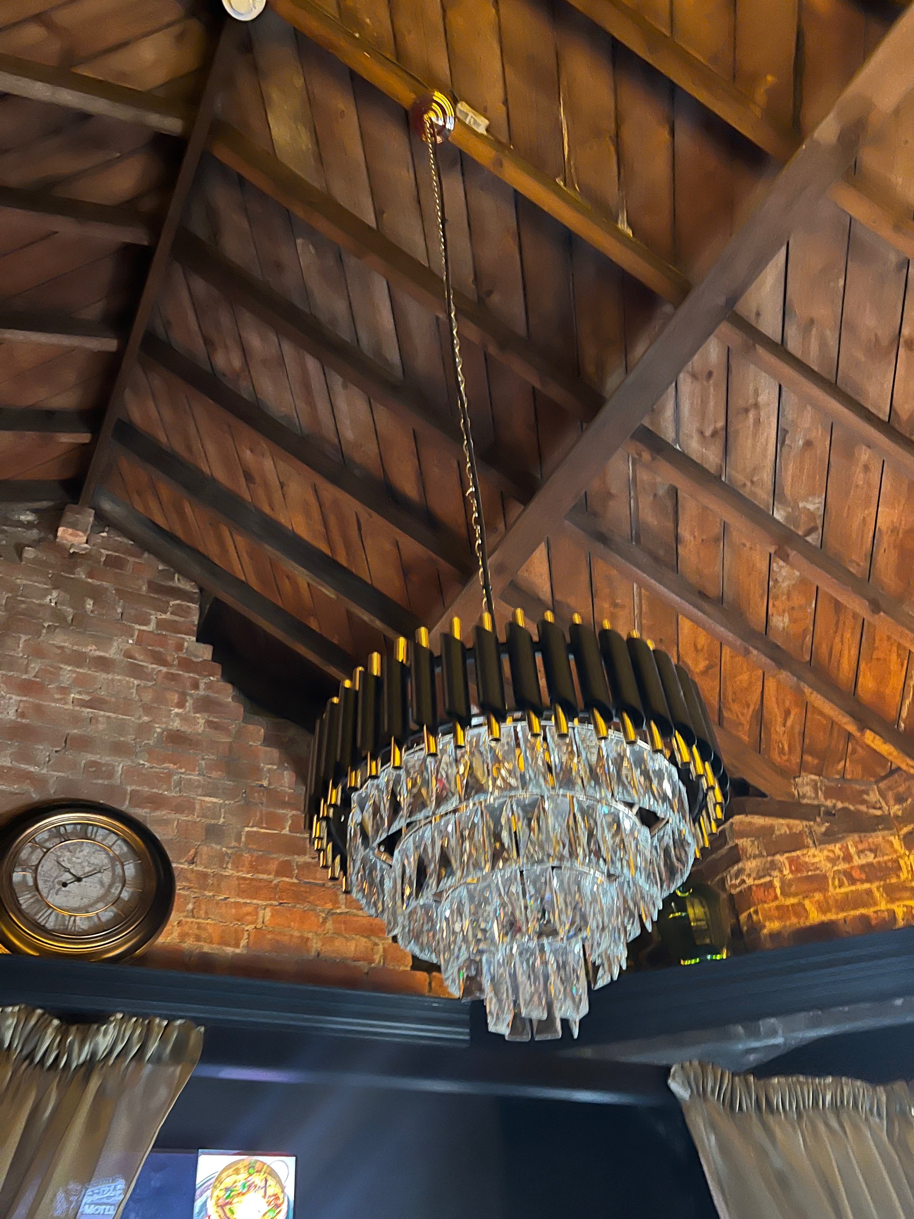 VORELLI Milltimber Pendant Light installed beneath a vaulted ceiling with tiered crystal drops and cylinder frame