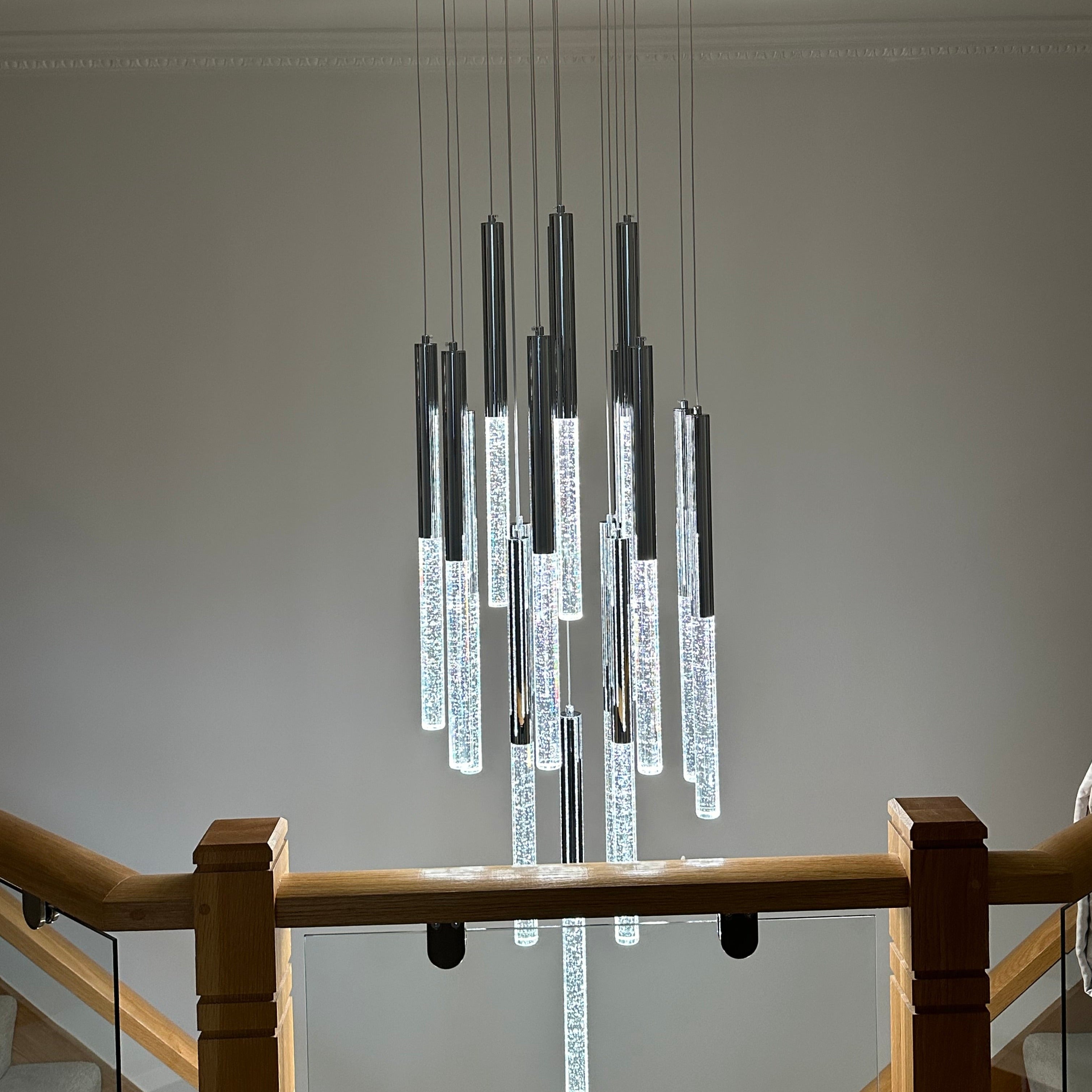 Detailed view of illuminated crystal pendants on VORELLI® Nyon pendant staircase chandelier