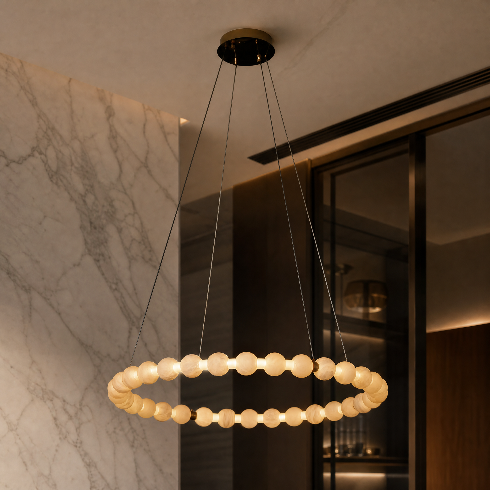 Detailed closeup of the smooth marble spheres and illuminated ring of the VORELLI Orbella Circular Chandelier.