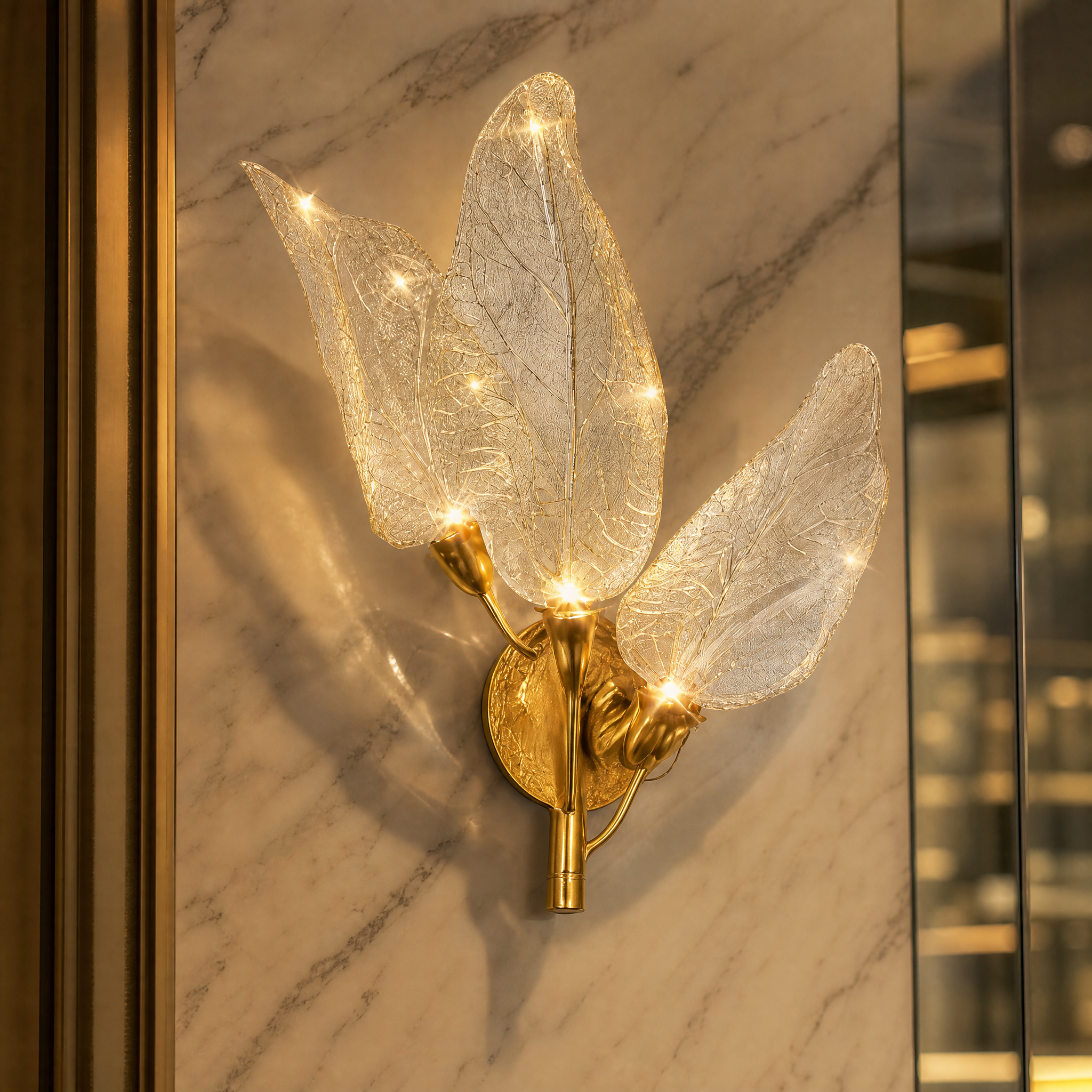 A detailed closeup of the VORELLI Ottobre wall light, showcasing the intricate, delicate texture of the sculpted glass leaves and its softly glowing ambiance.