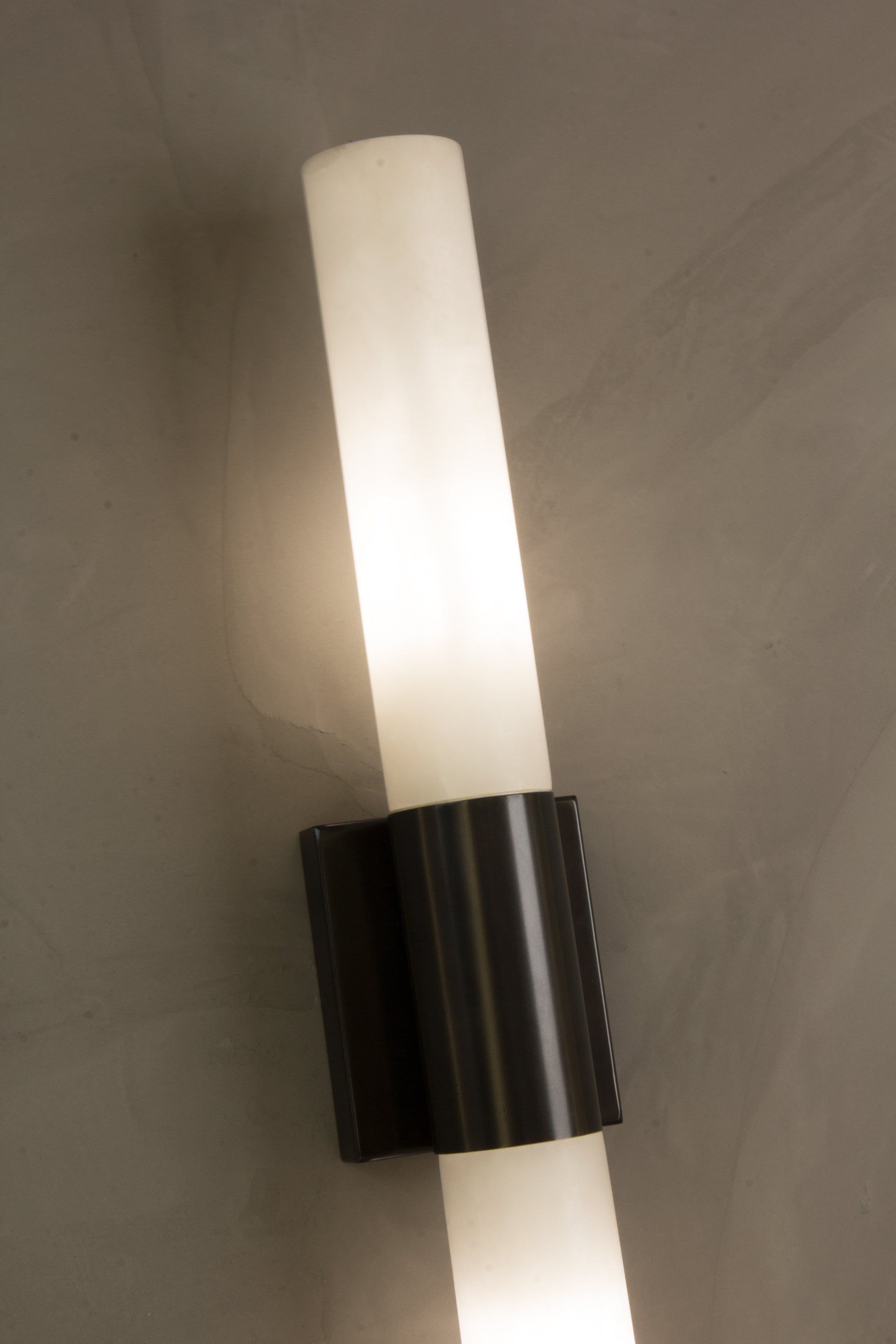 Close up of VORELLI® Palermo marble wall light highlighting vertical stone diffusers and architectural central accent