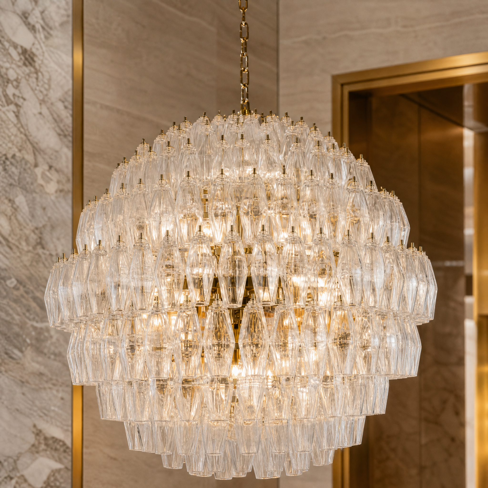 Extreme close-up of the vintage-inspired glass polyhedrons bolted onto the premium brass frame of the Pallinaro chandelier.