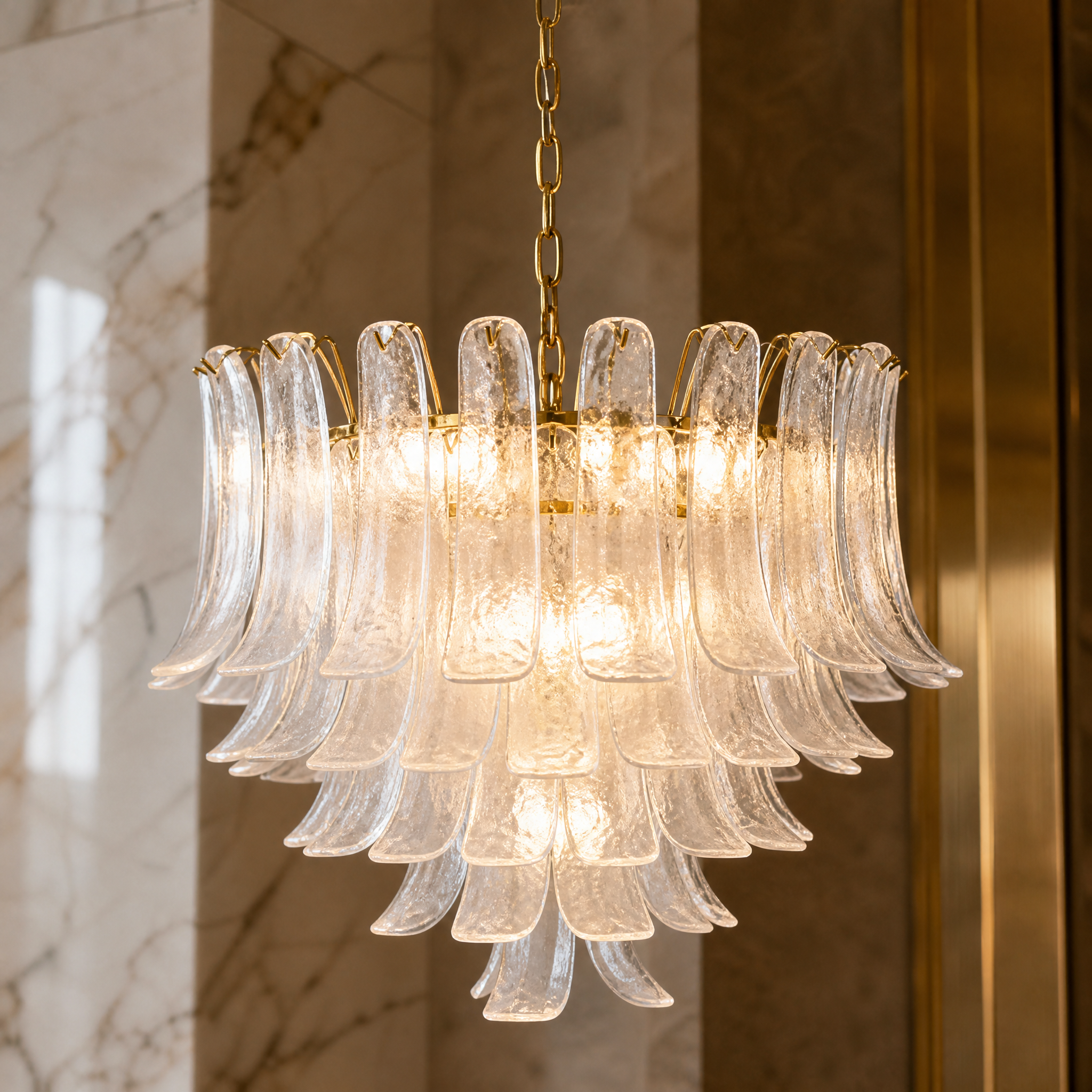 Macro shot of the curved clear glass panels and satin brass finish on the VORELLI Piccaro Circular Chandelier.