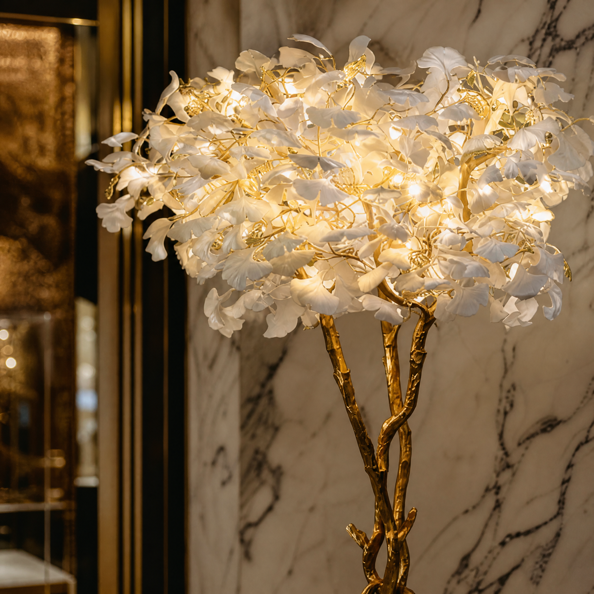 A detailed close-up of the VORELLI Prano floor lamp highlighting the softly layered floral glass and intricate flowing branches.