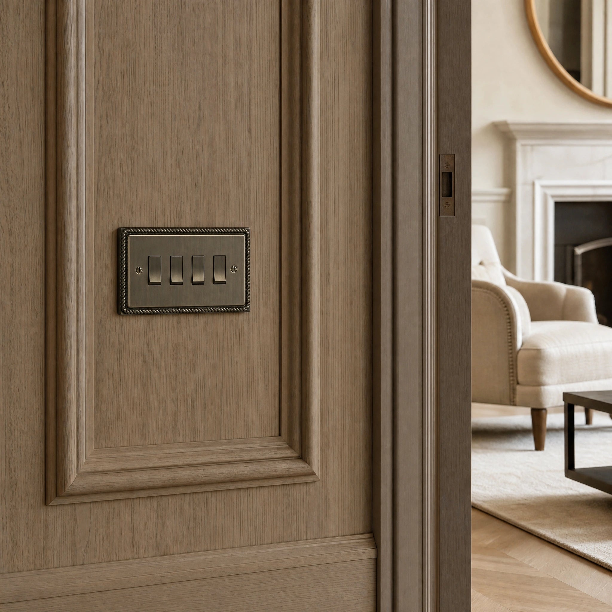 Luxury antique brass rocker switch installed within feature wall beside an elegant doorway with refined timber panelling in a UHNW interior by VORELLI®.