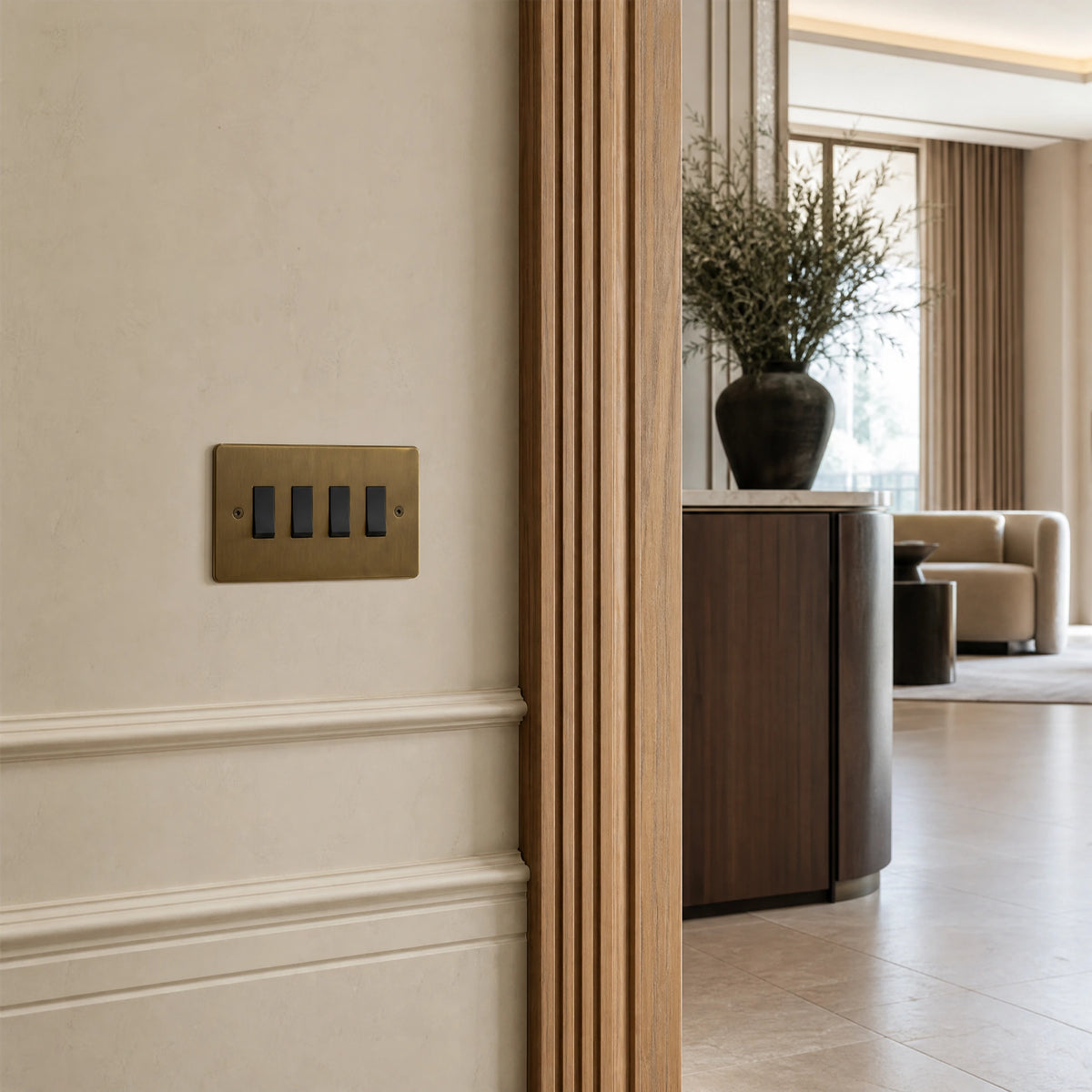 Luxury antique brass rocker switch installed within feature wall beside an elegant doorway with refined timber panelling in a UHNW interior by VORELLI®.