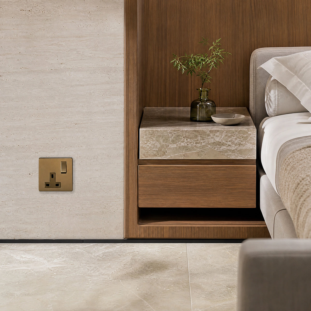 Luxury antique brass single socket installed within bespoke bedside joinery or stone wall beside a luxury seating area in a UHNW interior by VORELLI®.
