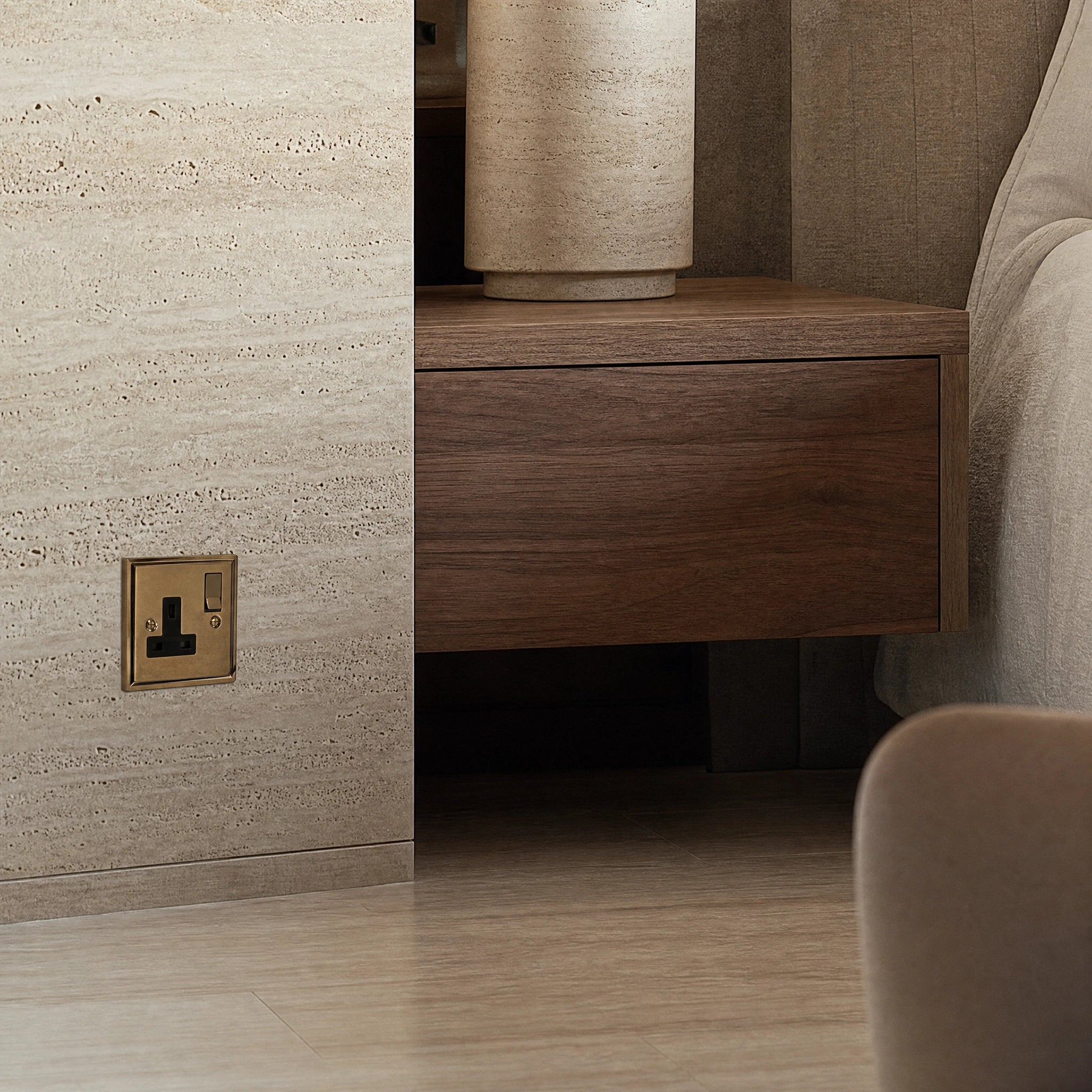 Luxury antique brass single socket installed within bespoke bedside joinery or stone wall beside a luxury seating area in a UHNW interior by VORELLI®.