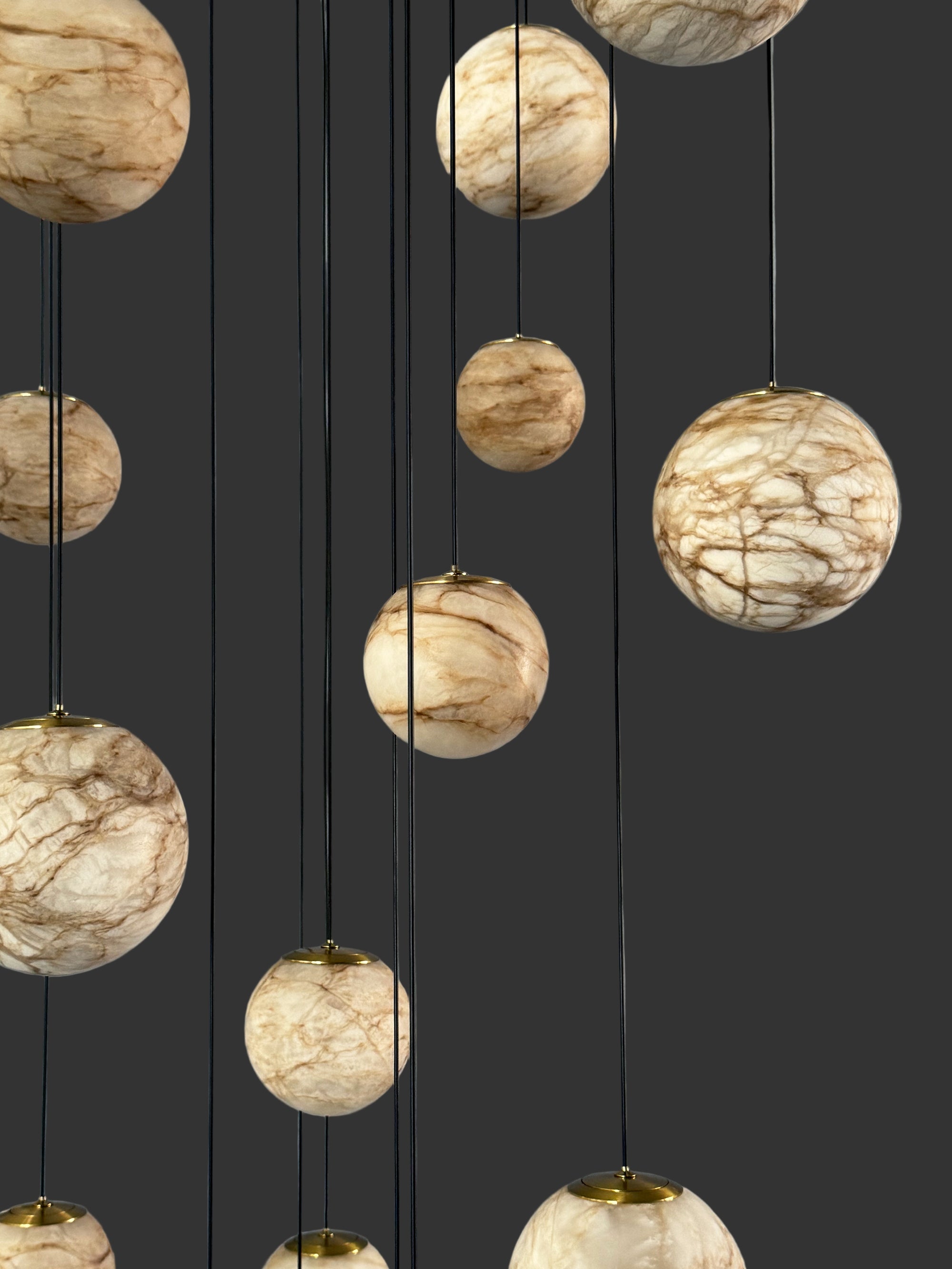 Long marble staircase lighting by VORELLI® with cascading globe pendants forming an elegant statement in refined architectural settings