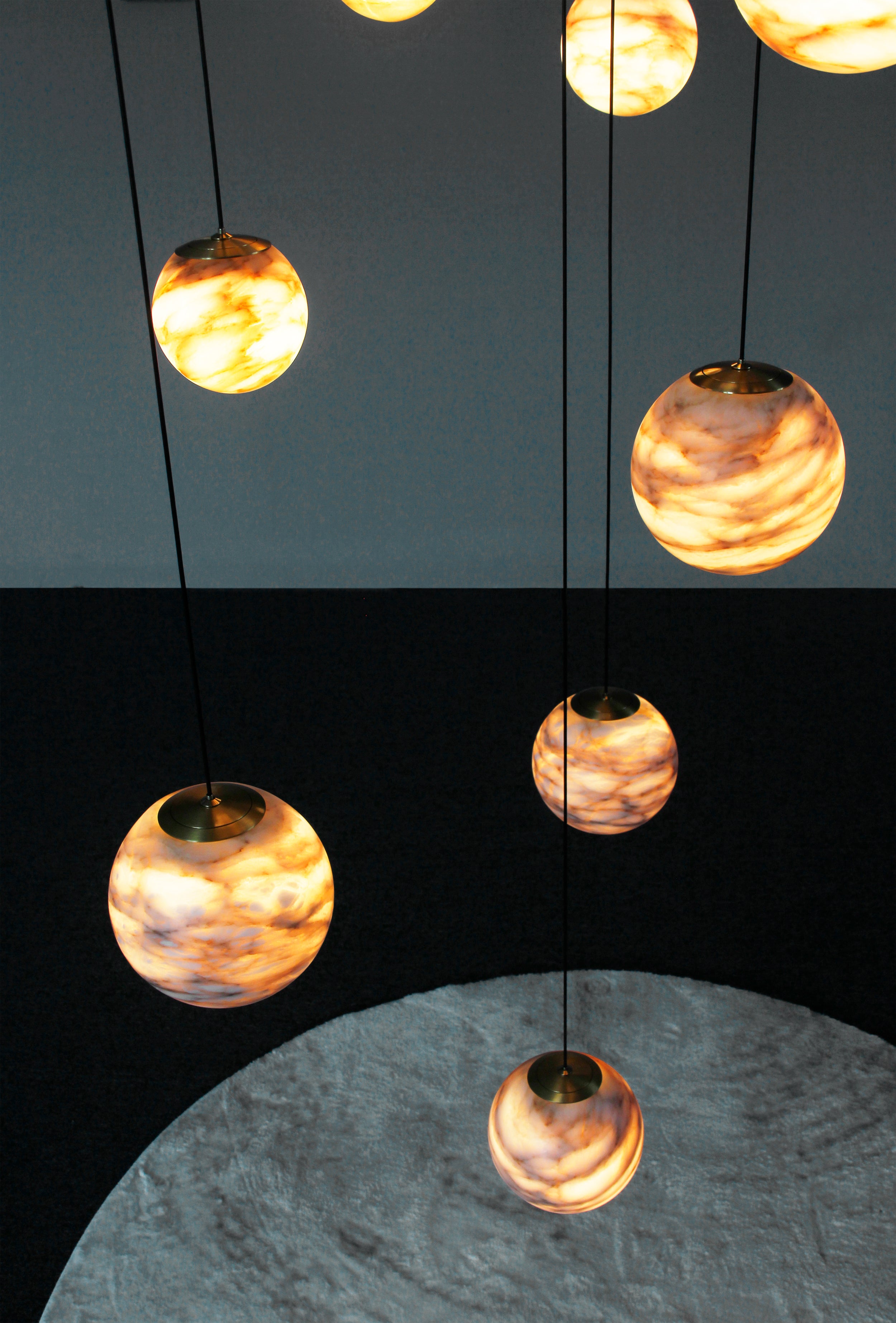 Luxury marble chandelier by VORELLI® with cascading illuminated stone spheres crafted for elegant contemporary interiors