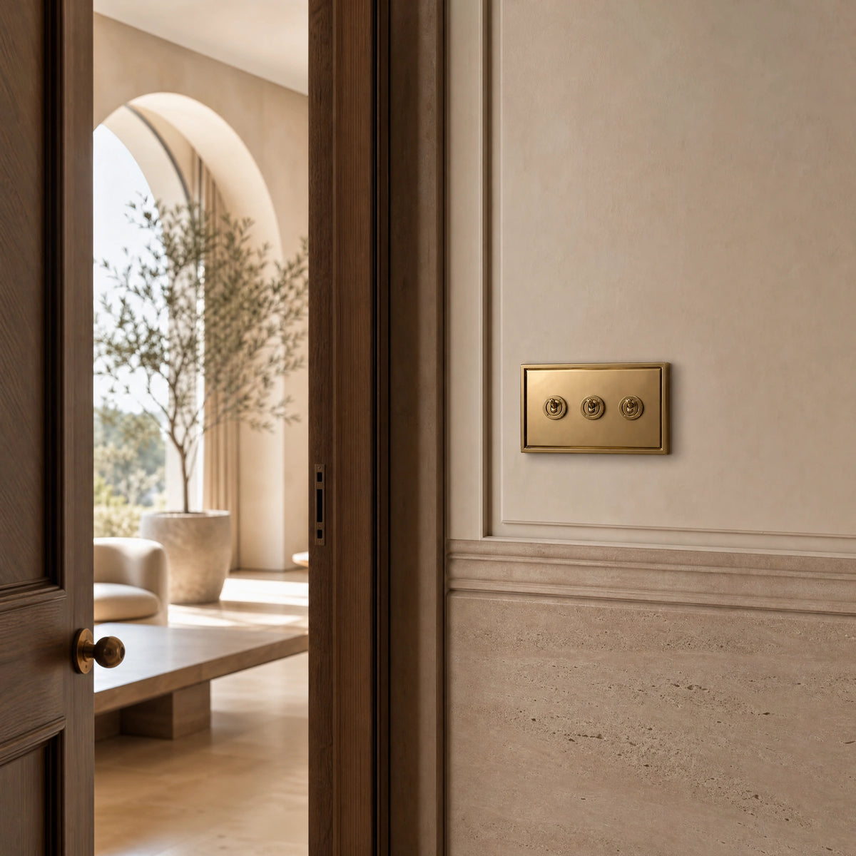 Luxury antique brass toggle switch installed within feature wall beside an elegant doorway with refined timber panelling in a UHNW interior by VORELLI®.