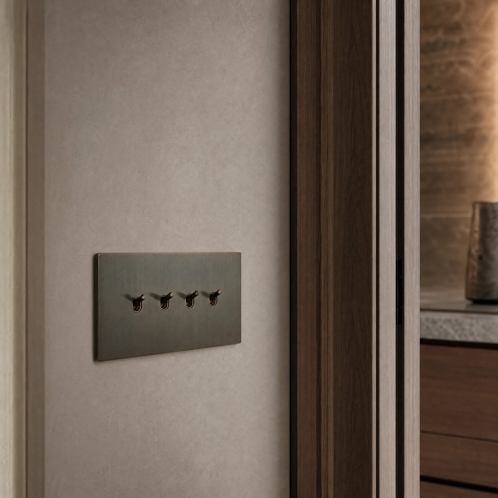 Close-up of a luxury sienna toggle switch installed within feature wall beside an elegant doorway with refined timber panelling by VORELLI®.
