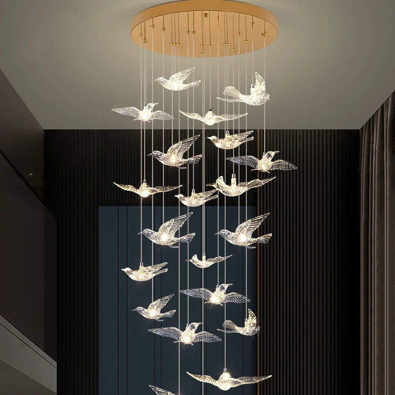 Illuminated sculptural bird pendants with a soft warm glow forming a modern luxury staircase lighting feature