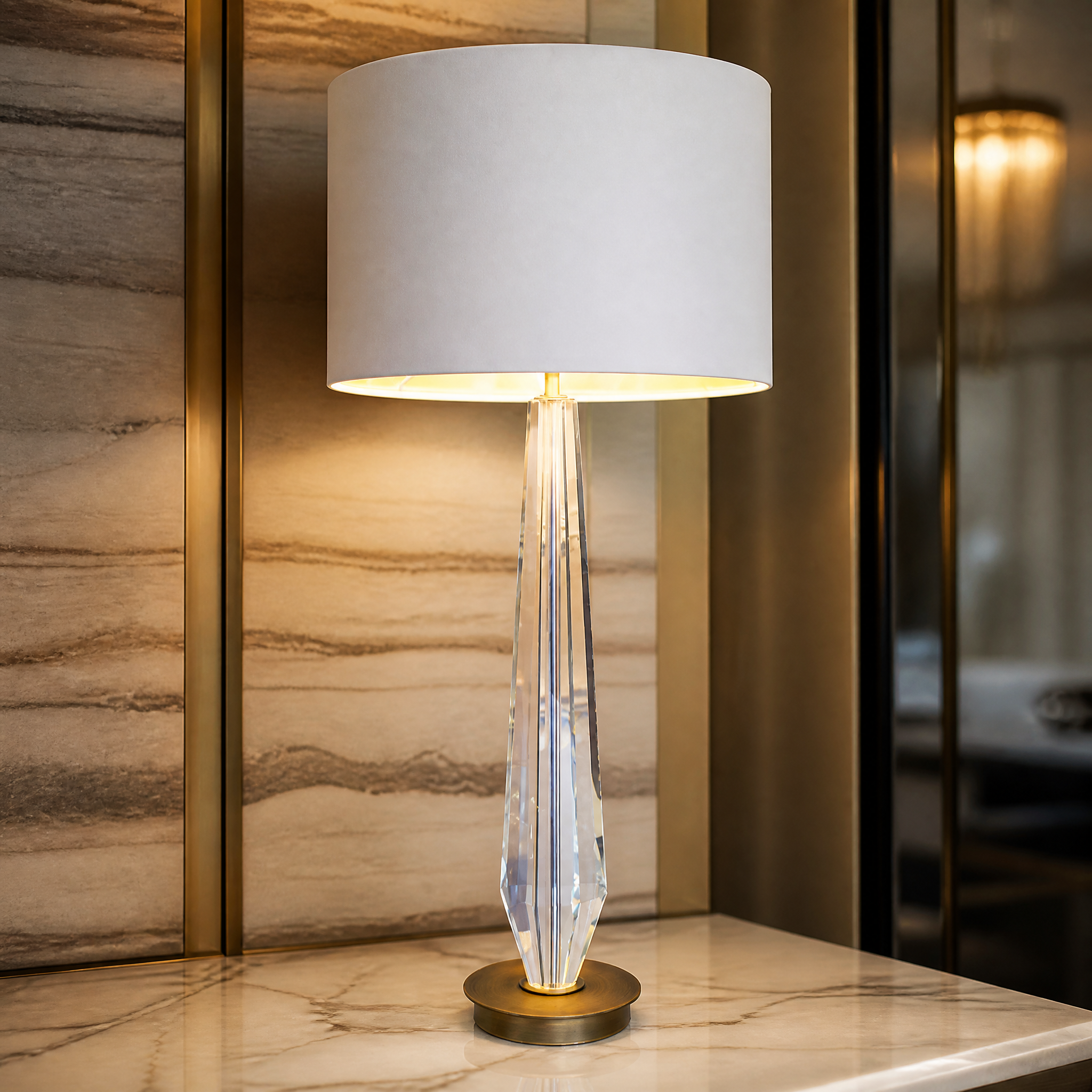 Macro view of the VORELLI Valcren lamp's sculpted crystal base, elongated glass form, and refined antique brass detailing.