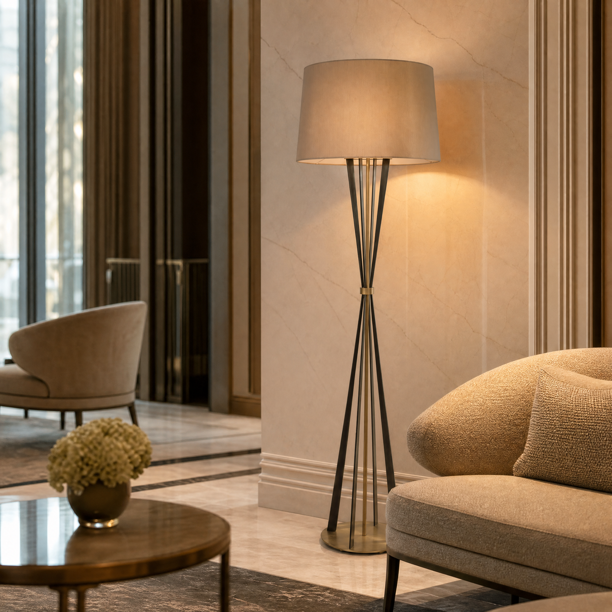 The sculpted dual-tone Valtero brass floor lamp casting a sophisticated ambient glow in an upscale boutique hotel lounge or hospitality suite.