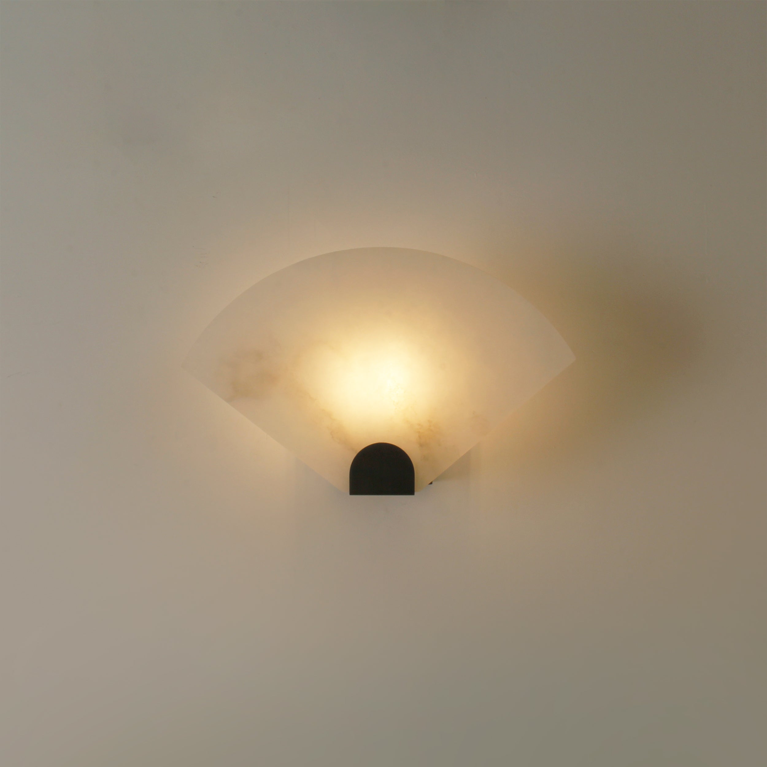 Modern marble wall light with curved silhouette creating warm architectural lighting effect